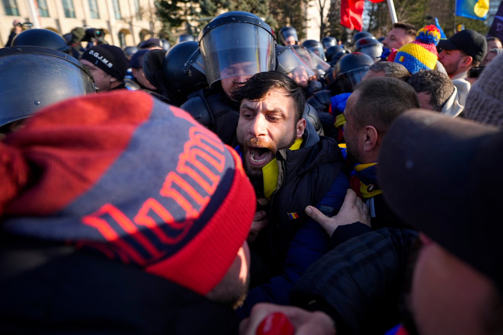 Riot police scuffle with supporters of Calin Georgescu, the winner of Romania's first round of presidential election which the Constitutional Court later annulled, who broke through police lines in front of the government headquarters, in Bucharest, Romania, Monday, Feb. 10, 2025. (AP Photo/Vadim Ghirda)