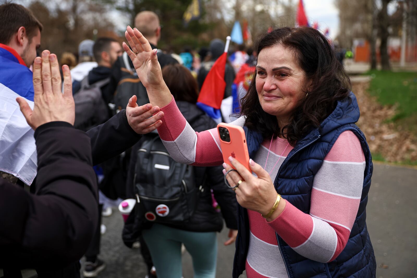 A woman cries as students and anti-government protesters pass trough her village as they march to Belgrade for a joint protest in Nova Pazova, Serbia, Friday, March 14, 2025. (AP Photo/Armin Durgut)