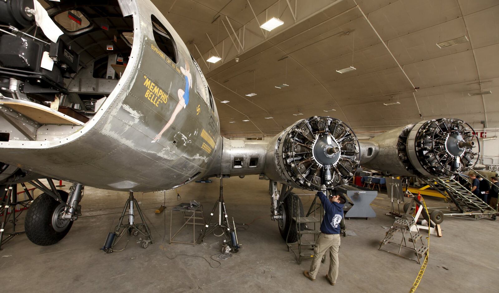 The Memphis Belle restoration at the National Musem of the United States Air Force is on track for completion in 2015. Exhibit Specialists are busy with metal work as wingtip and tail skins are fabricated and attached. Casey Simmons checks the engine cowl work. —Staff Photo by Ty Greenlees