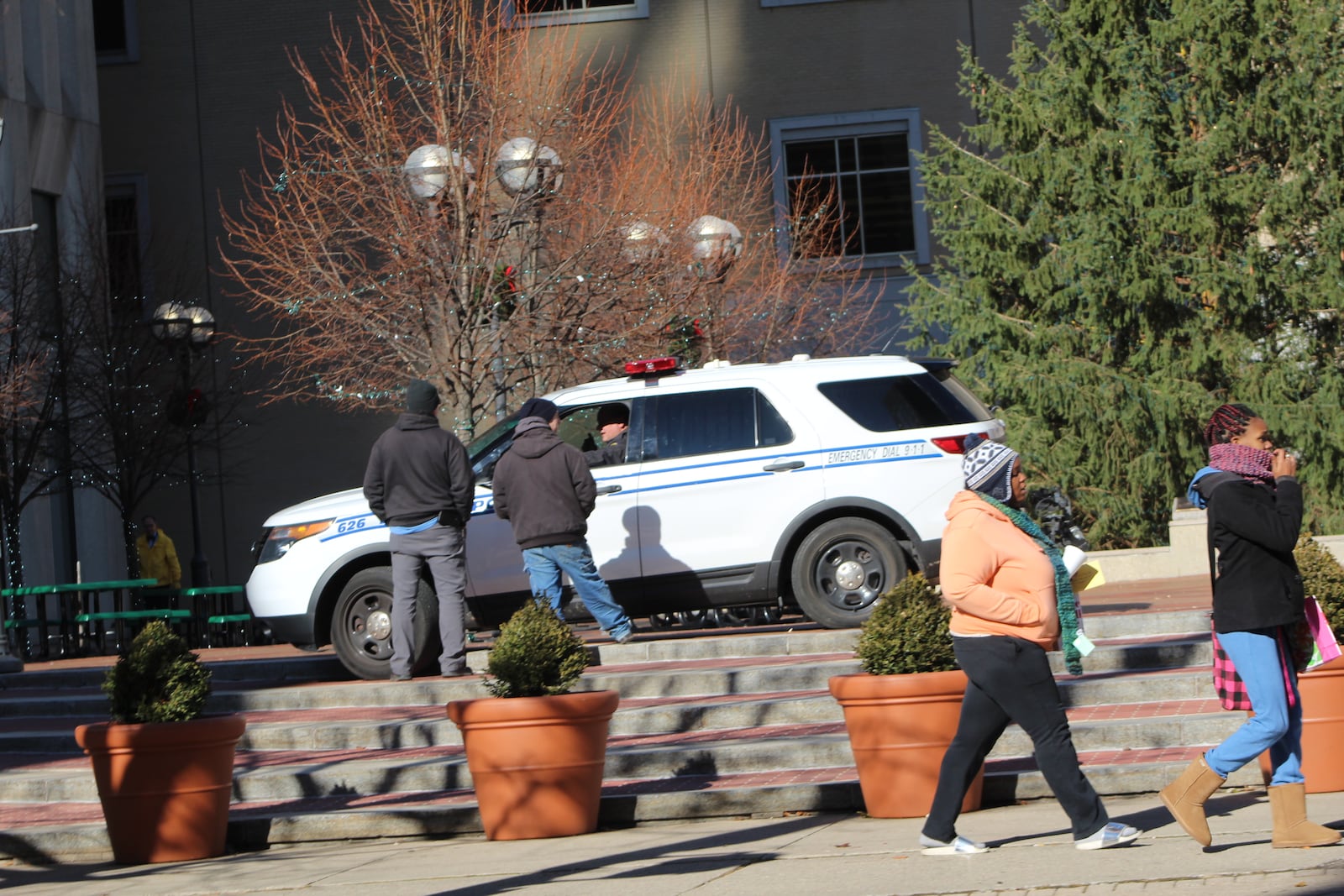 A Dayton police officer speaks to citizens at Courthouse Square last winter. CORNELIUS FROLIK / STAFF