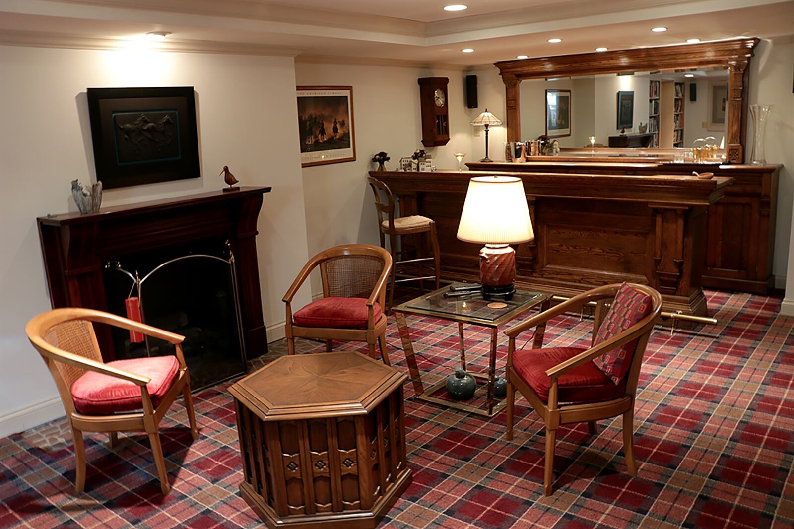 A lower-level recreation room has a carved wood bar with brass foot rail and matching wall cabinets and countertops. The basement also has a full bathroom, laundry room, a workshop, wine cellar and unfinished storage. CONTRIBUTED PHOTO BY KATHY TYLER