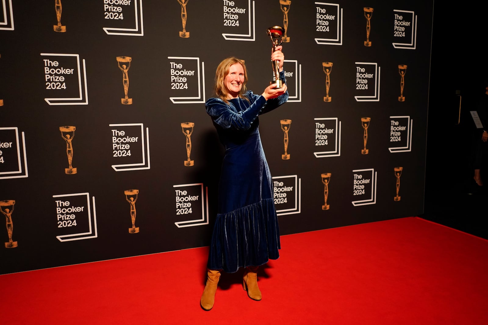 Samantha Harvey poses with the trophy after winning the Booker Prize award 2024, in London, Tuesday, Nov. 12, 2024. (AP Photo/Alberto Pezzali)