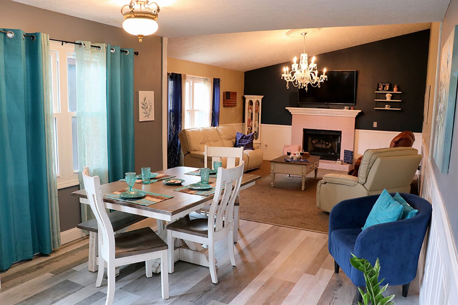 The kitchen and dining area and great room create an open floor plan. The great room has a vaulted ceiling, rear-facing windows and a brick, propane fireplace with dentil wood mantel. Wainscoting surrounds the great room and extends into the dining area. CONTRIBUTED PHOTO BY KATHY TYLER