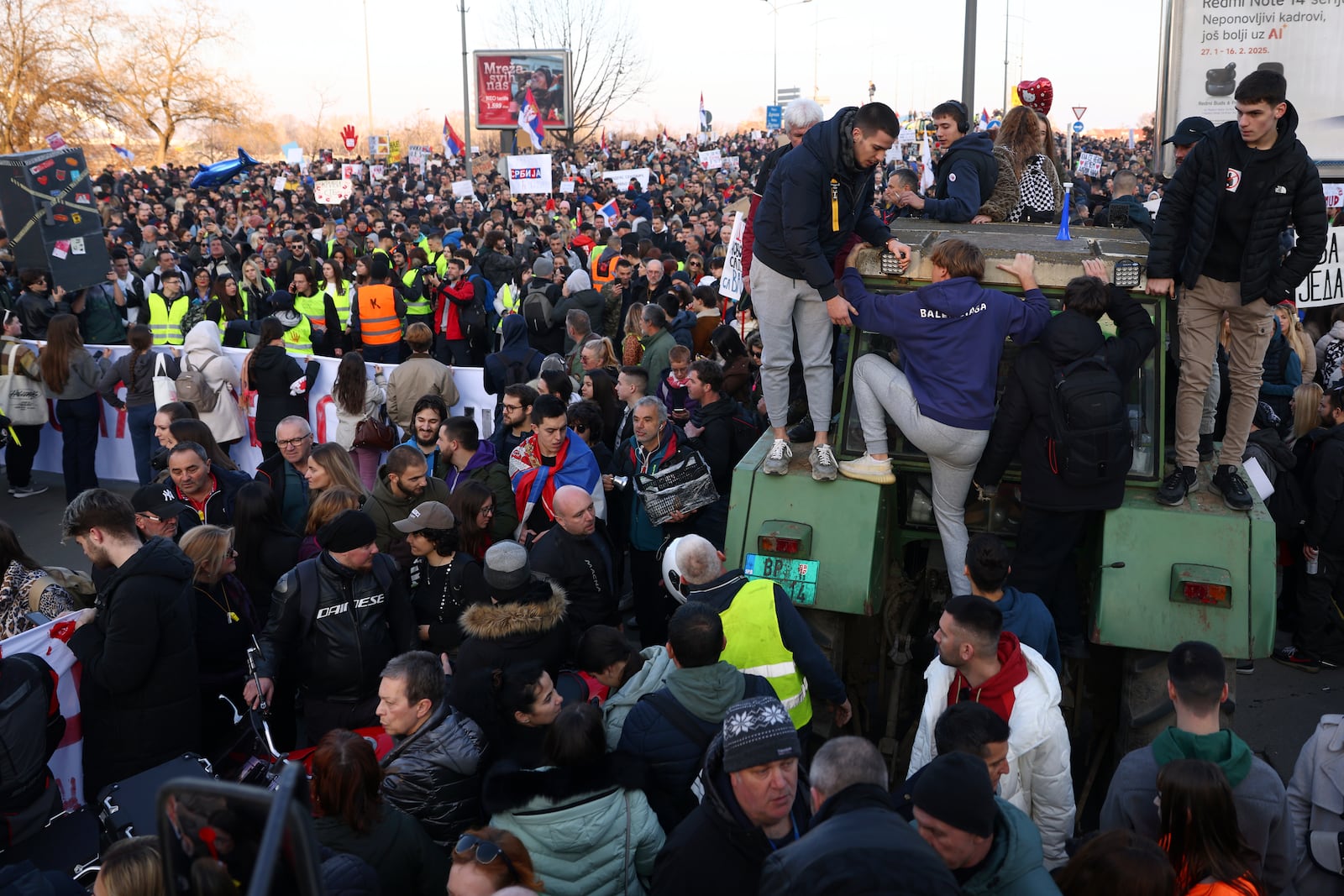 People climb up a tractor during a protest over the collapse of a concrete canopy that killed 15 people more than two months ago, in Novi Sad, Serbia, Saturday, Feb. 1, 2025. (AP Photo/Armin Durgut)