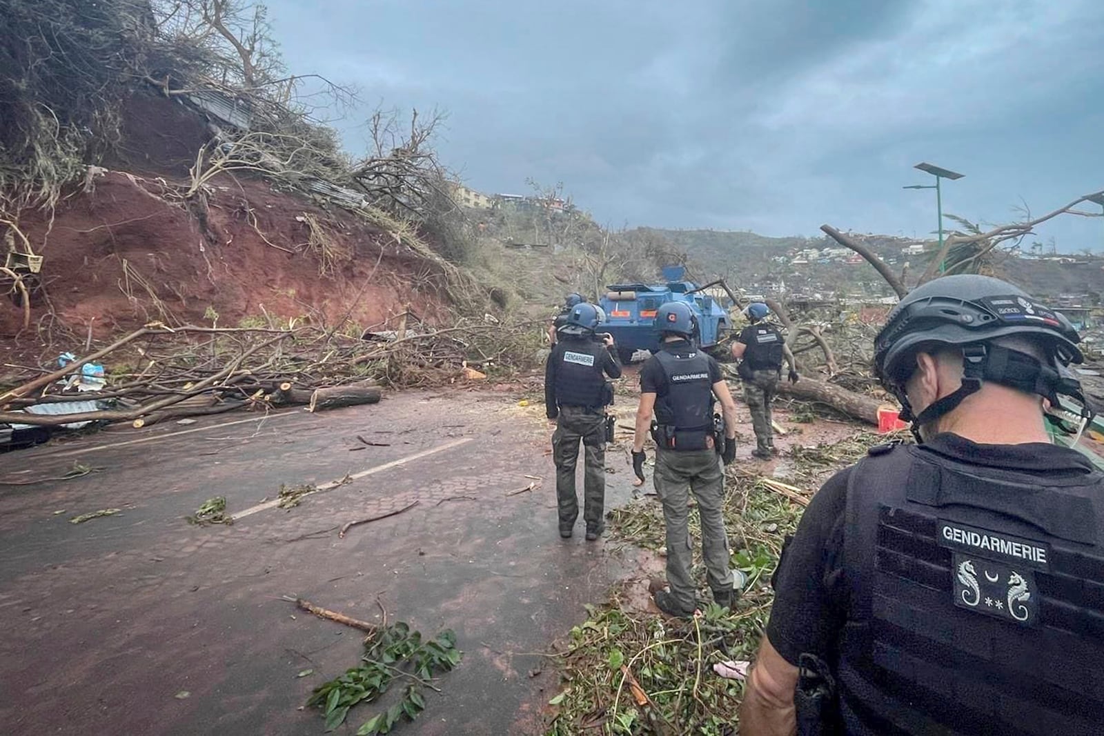 This photo provided Monday, Dec.16, 2024 by the Gendarmerie Nationale shows Gendarmes clearing a road, Sunday, Dec. 15, 2024 in Mayotte as France rushed rescue teams and supplies to its largely poor overseas department in the Indian Ocean that has suffered widespread destruction. (Gendarmerie Nationale via AP)