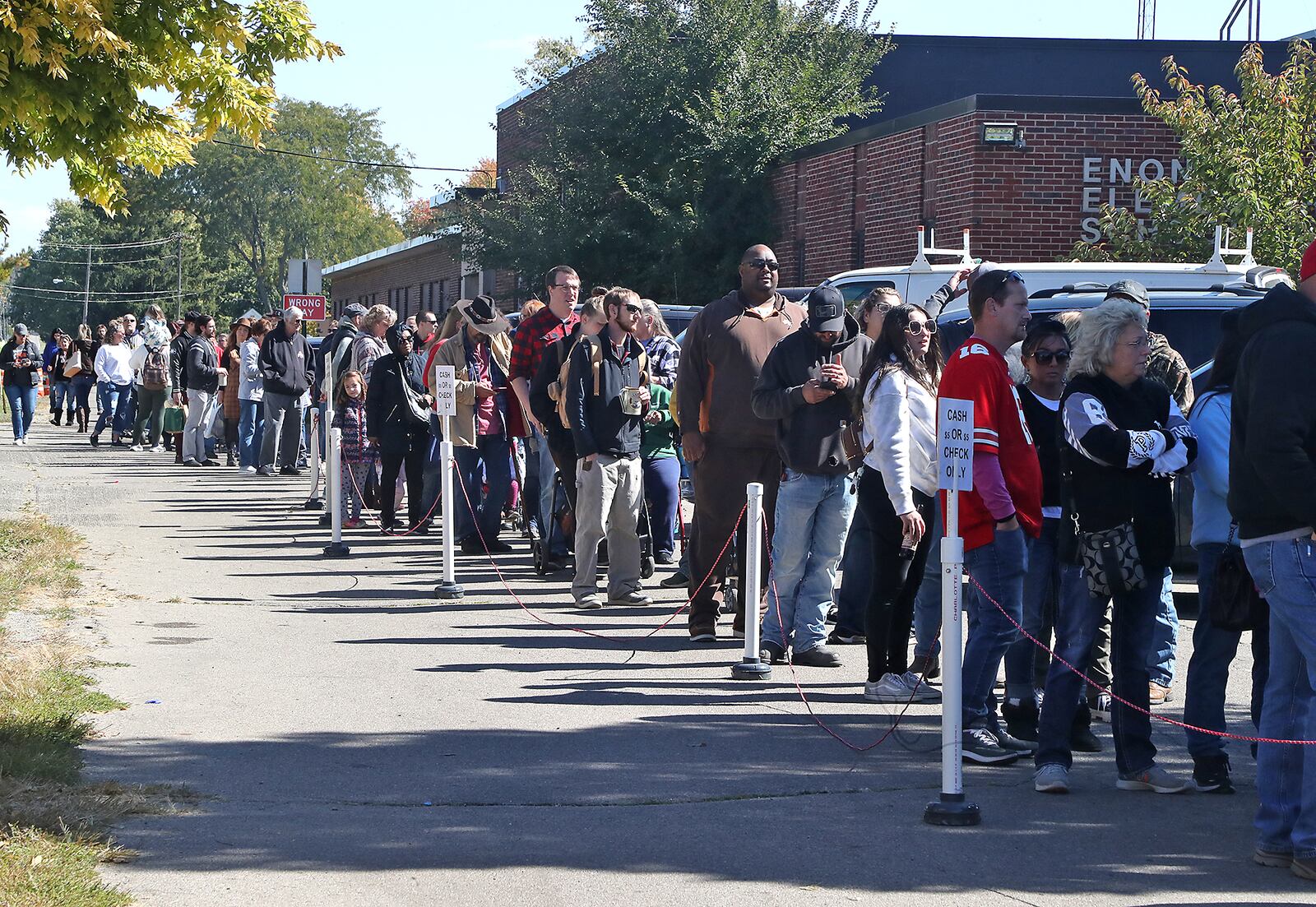 Dozens of people wait in line for a jar of fresh apple butter Saturday, Oct. 8, 2022 at the annual Enon Apple Butter Festival. BILL LACKEY/STAFF