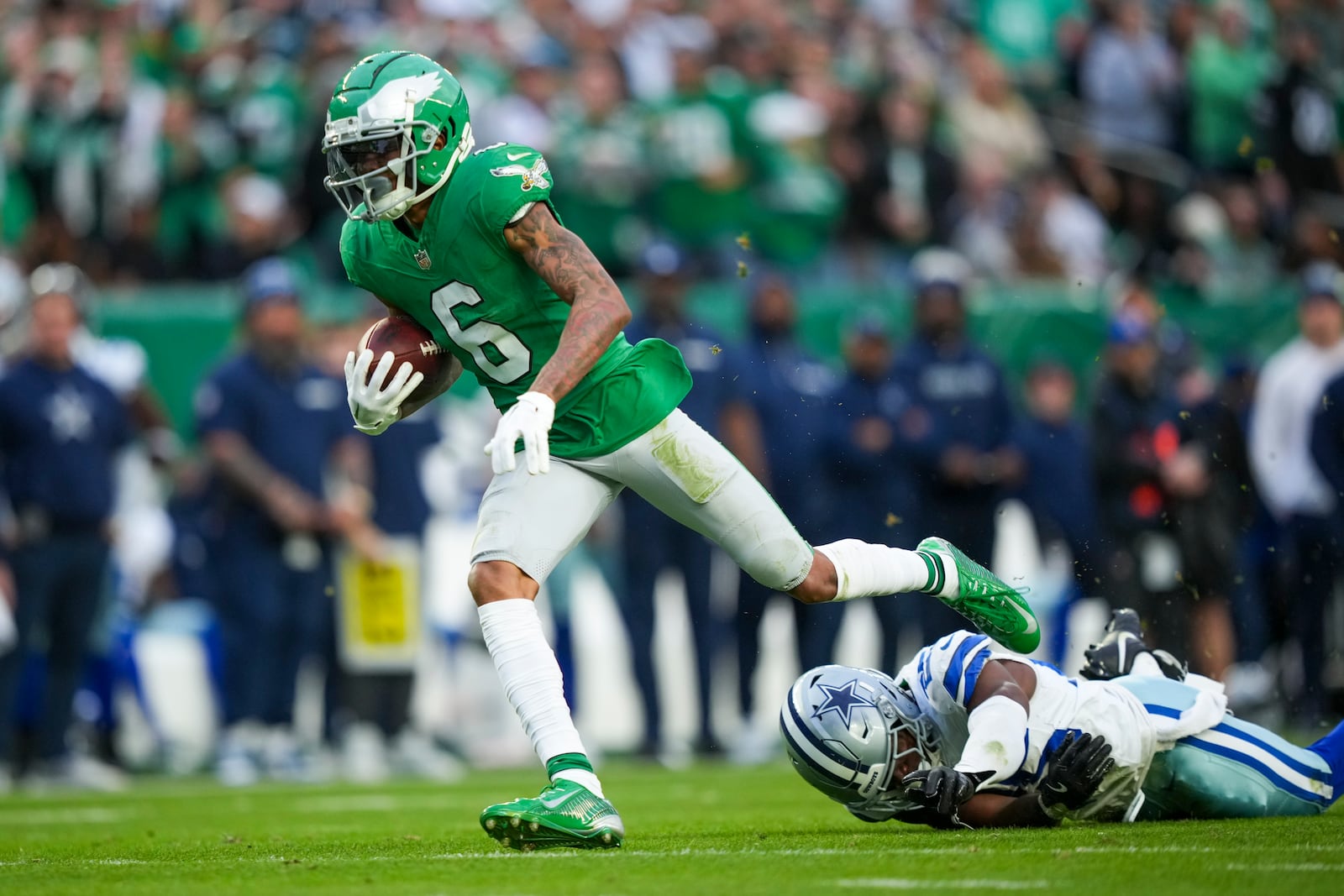 Philadelphia Eagles wide receiver DeVonta Smith (6) avoids a tackle by Dallas Cowboys cornerback Andrew Booth Jr. while scoring on a touchdown catch during the second half of an NFL football game, Sunday, Dec. 29, 2024, in Philadelphia. (AP Photo/Matt Slocum)