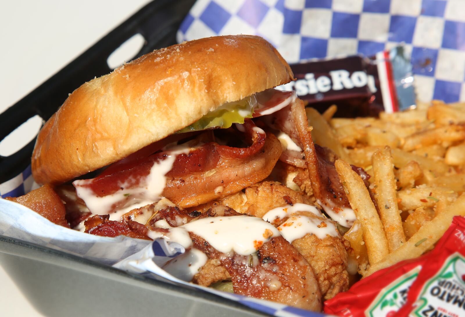 The Rolling Indulgence food truck's Chicken Bacon Ranch Sammy is made with homestyle fried chicken, brown sugar bacon, creamy ranch dressing, shredded lettuce, Roma tomato, light honey mustard and served on a toasted garlic brioche bun. LISA POWELL / STAFF