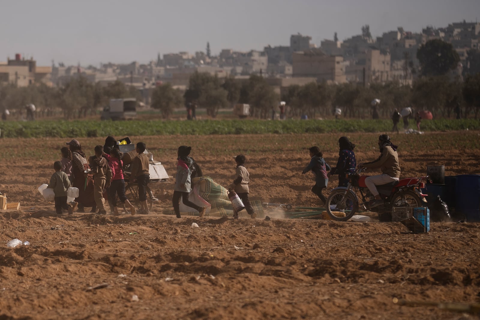 FILE - People are dispersed by Syrian fighters during looting at a residential complex of former Bashar Assad's military officers at the village of Husseiniyeh, in the outskirts of Damascus, Syria, Sunday, Dec. 15, 2024. (AP Photo/Leo Correa, File)