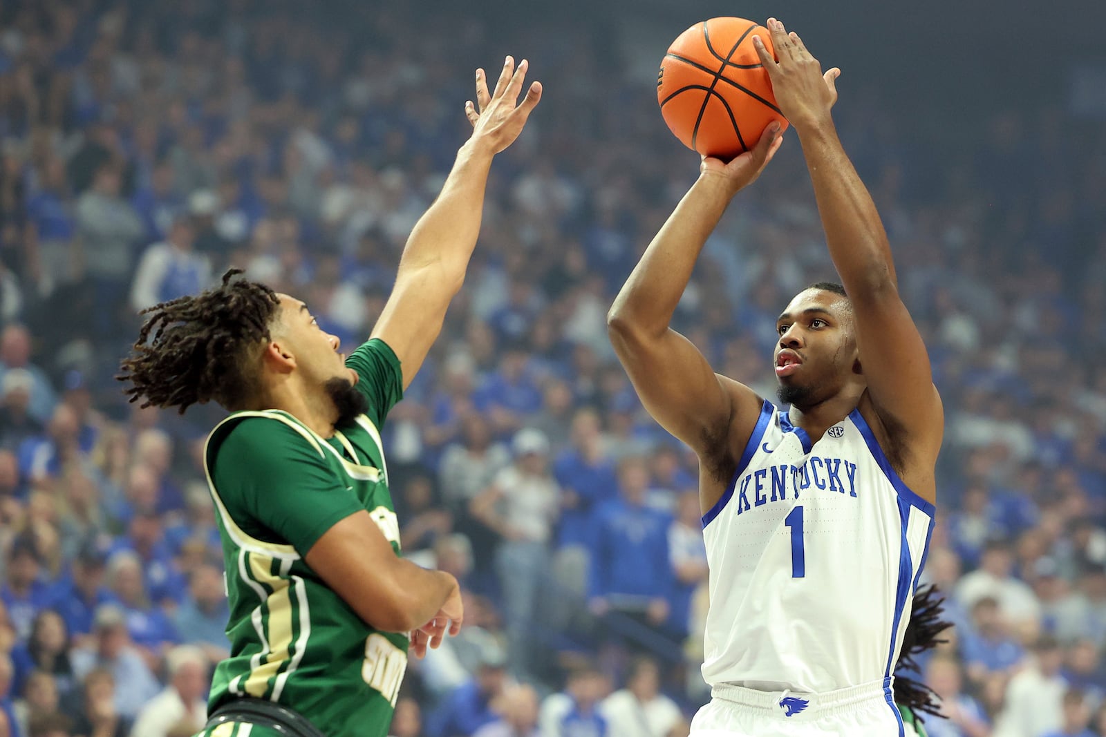 Kentucky's Lamont Butler (1) shoots while pressured by Wright State's Logan Woods, left, during the first half of an NCAA college basketball game in Lexington, Ky., Monday, Nov. 4, 2024. (AP Photo/James Crisp)