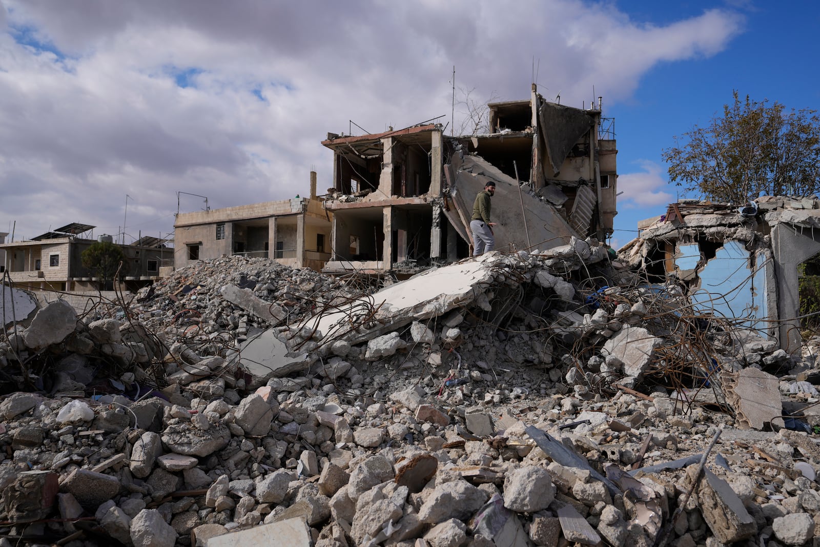 A man inspects a building destroyed in Israeli airstrikes in Baalbek, eastern Lebanon, Thursday, Nov. 28, 2024. (AP Photo/Hassan Ammar)