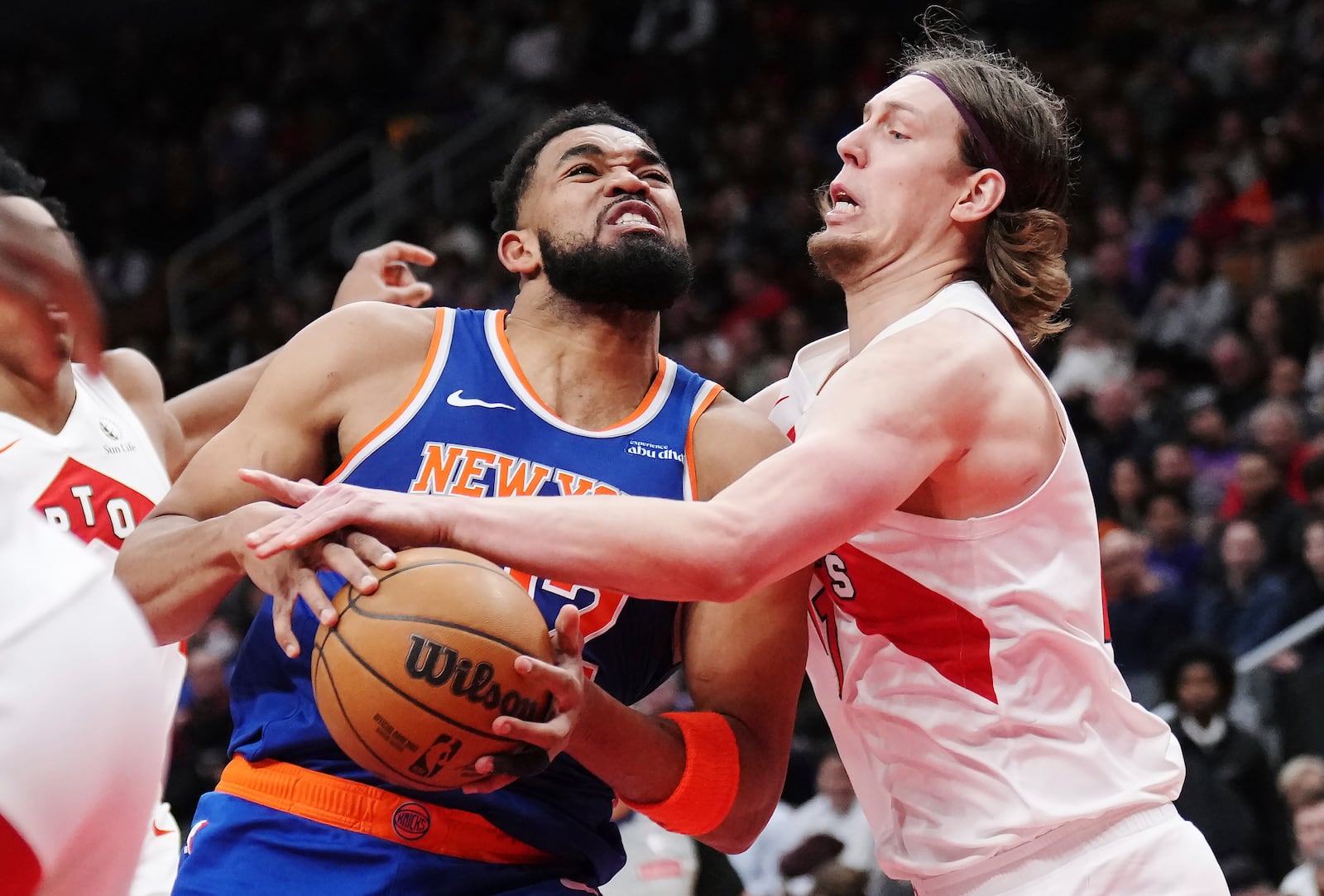 New York Knicks' Karl-Anthony Towns, left, drives at Toronto Raptors' Kelly Olynyk, right, during the second half of an NBA basketball game in Toronto, Tuesday, Feb. 4, 2025. (Nathan Denette/The Canadian Press via AP)