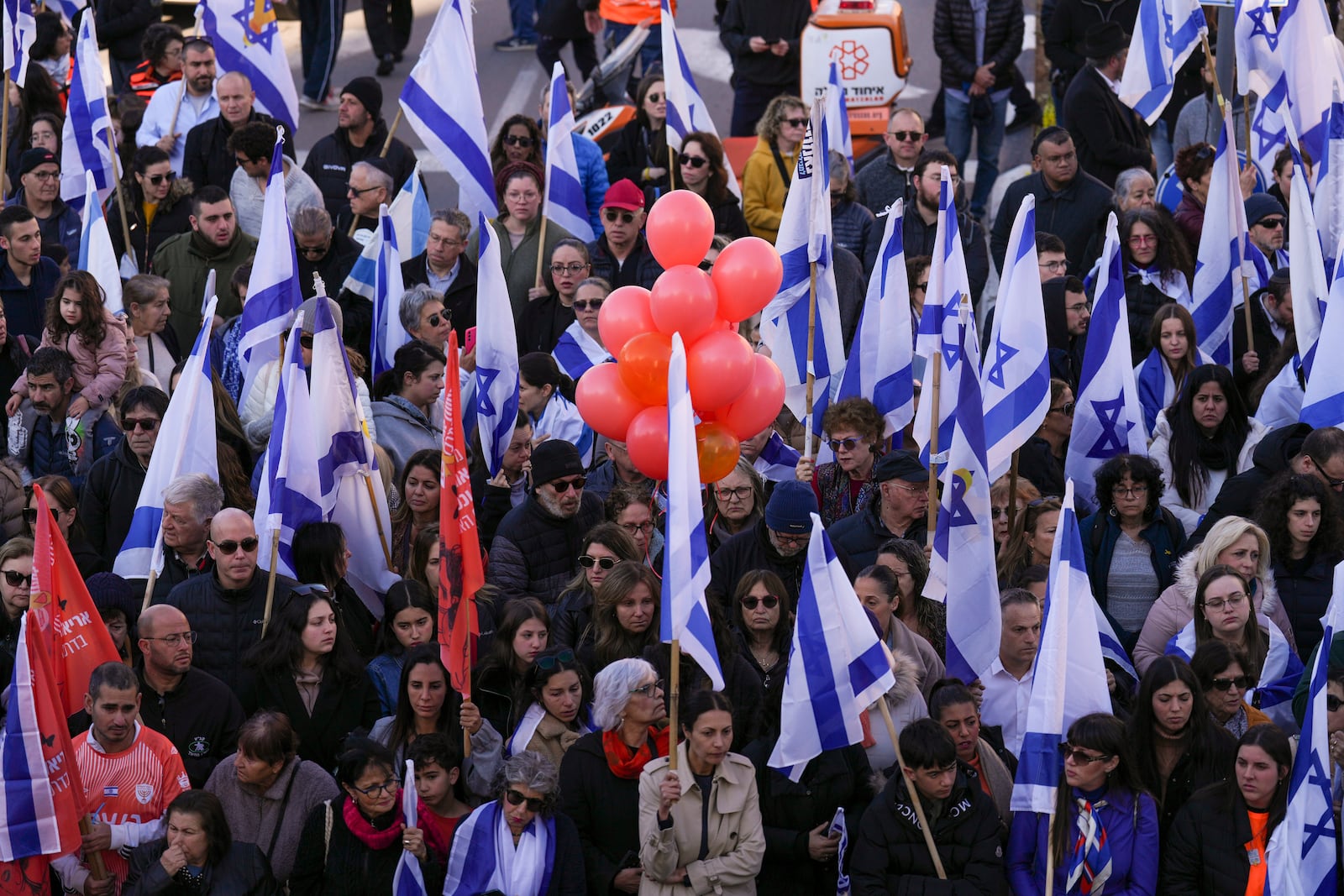 Mourners attend the funeral procession of slain hostages Shiri Bibas and her two children, Ariel and Kfir, in Rishon Lezion, Israel, Wednesday, Feb. 26, 2025. The mother and her two children were abducted by Hamas on Oct. 7, 2023, and their remains were returned from Gaza to Israel last week as part of a ceasefire agreement with Hamas. (AP Photo/Ariel Schalit)