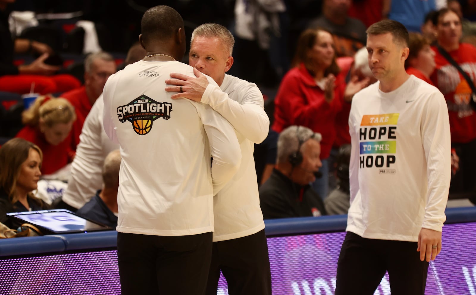 Ohio State's Chris Holtmann, center, hugs Dayton's Anthony Grant after an exhibition game on Sunday, Oct. 22, 2023, at UD Arena. David Jablonski/Staff