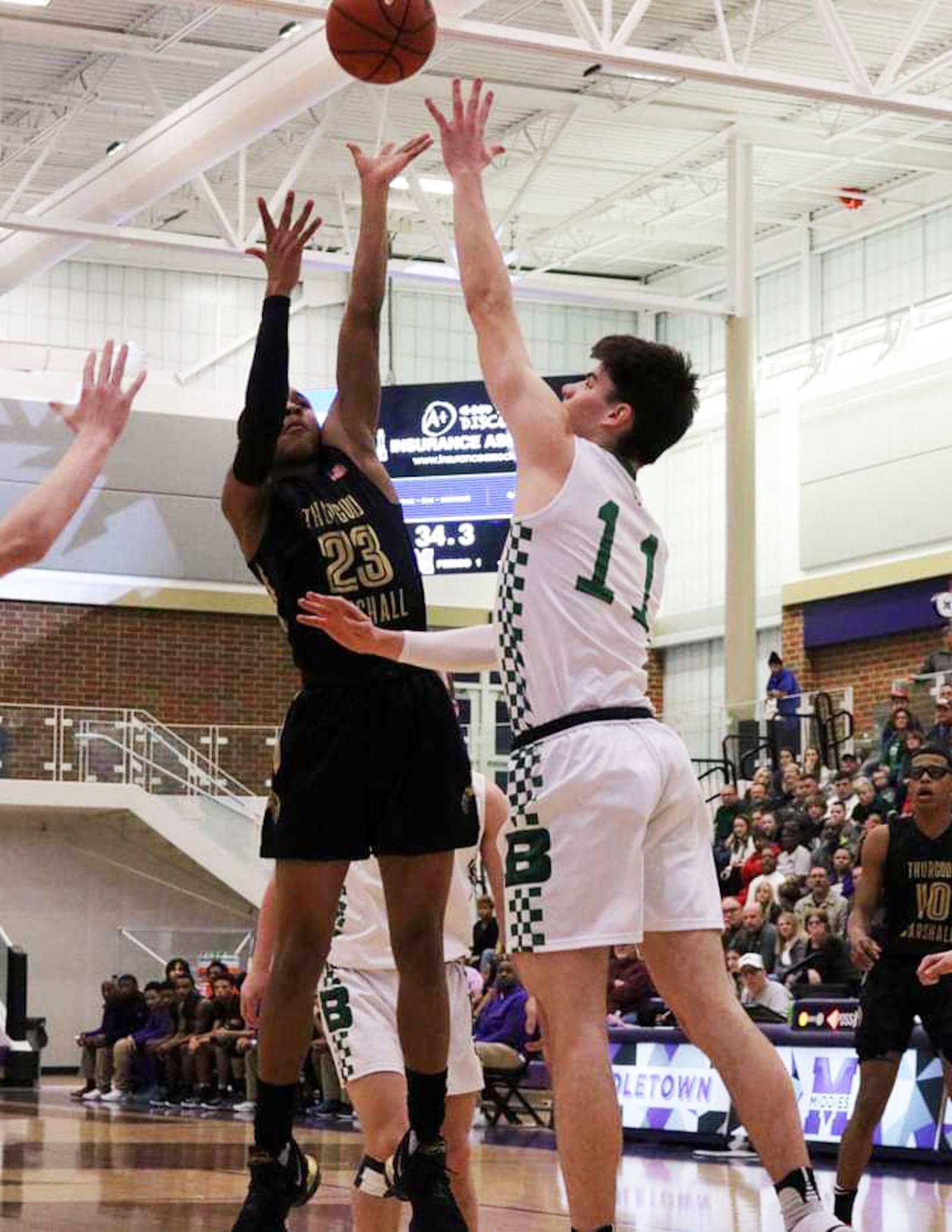 Badin's Spencer Giesting (11) goes after a shot by Thurgood Marshall's Mekhi Elmore (23) during a Division II district semifinal basketball game at Middletown's Wade E. Miller Arena. Thurgood Marshall won 67-53. CONTRIBUTED PHOTO BY TERRI ADAMS