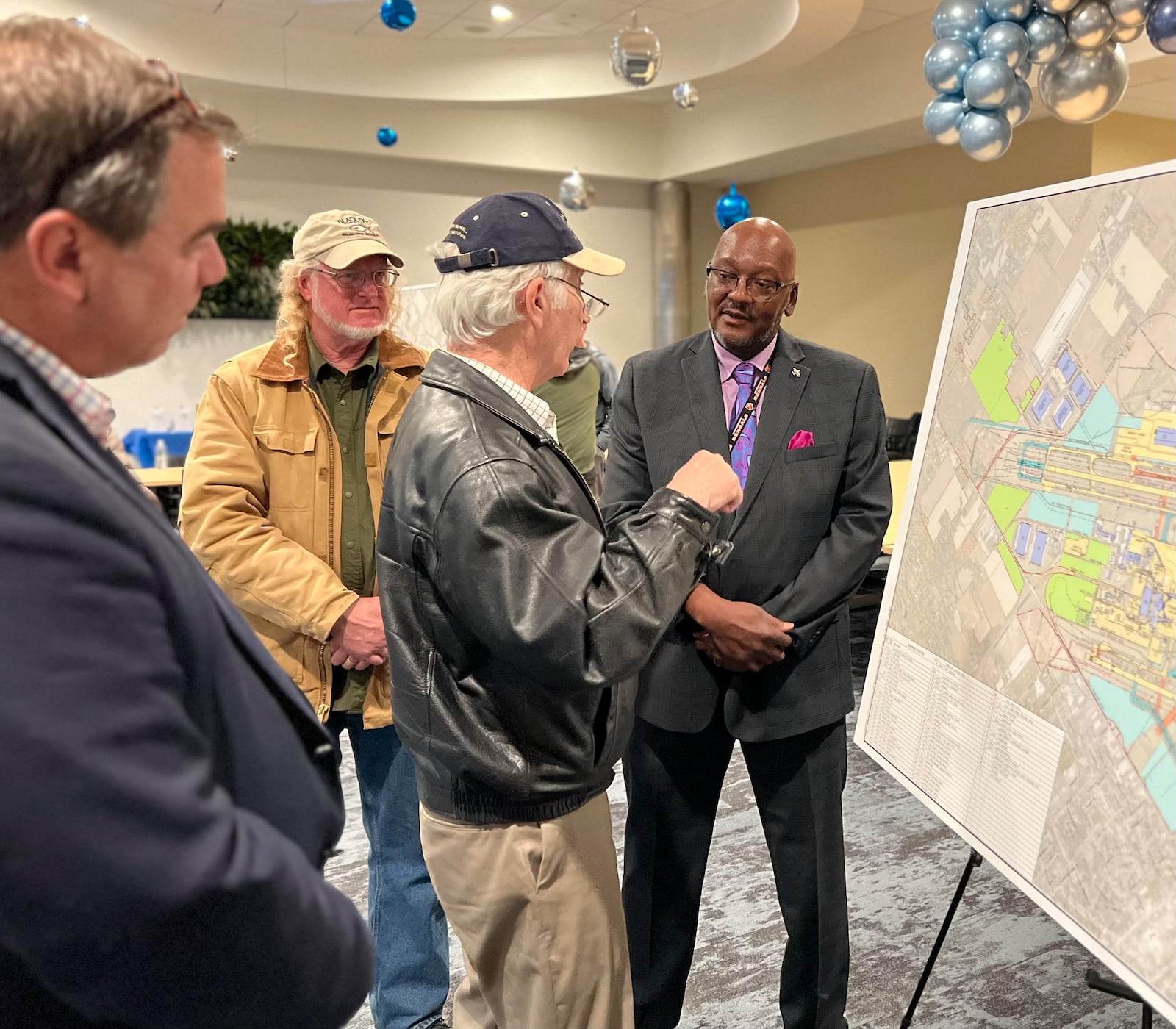 Dayton International Airport Director of Aviation Gil Turner, right, speaks with community members about the airport's 10-year masterplan during an open house Wednesday. AIMEE HANCOCK/STAFF