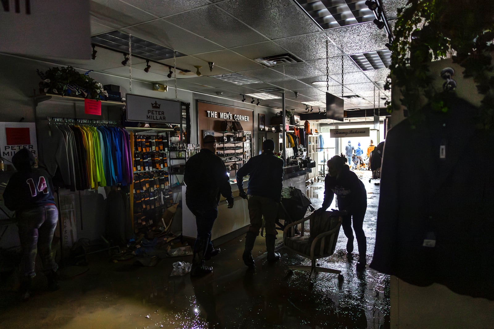 People clean up The Men's Corner after flooding in Pike County, Ky., Tuesday, Feb. 18, 2025, following a storm the previous weekend. (Ryan C. Hermens/Lexington Herald-Leader via AP)