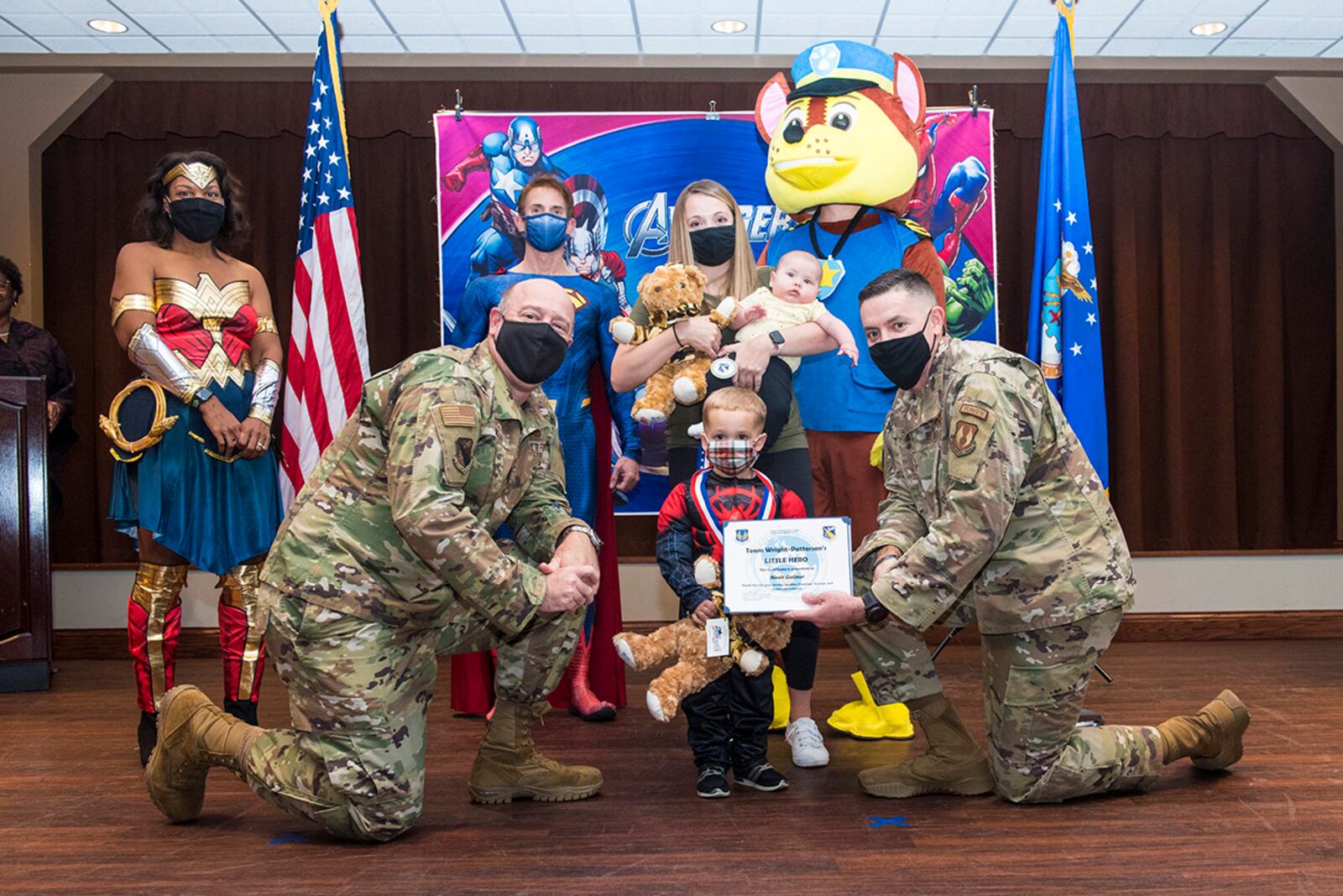 Col. Patrick Miller (left), 88th Air Base Wing and installation commander, and Chief Master Sgt. Jason Shaffer, 88 ABW command chief, pose for a photo with families during the “Little Heroes” event Nov. 5 honoring children of deployed parents at Wright-Patterson Air Force Base. U.S. AIR FORCE PHOTO/JAIMA FOGG