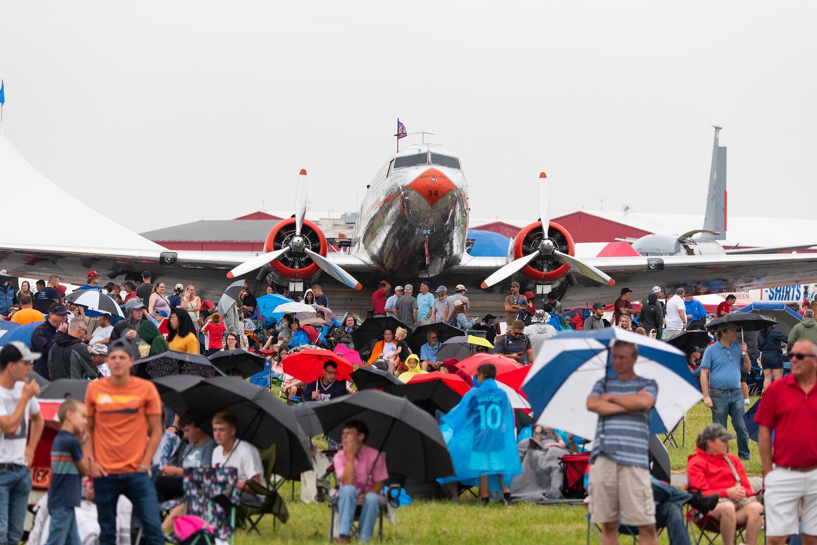 Part of the Dayton Air Show crowd settles in front of a vintage DC-3 airplane to watch the flying acts July 10 at Dayton International Airport. Intermittent rain throughout the afternoon did not stop the Air Force Thunderbirds and other top attractions from performing. (U.S. Air Force photo by R.J. Oriez)