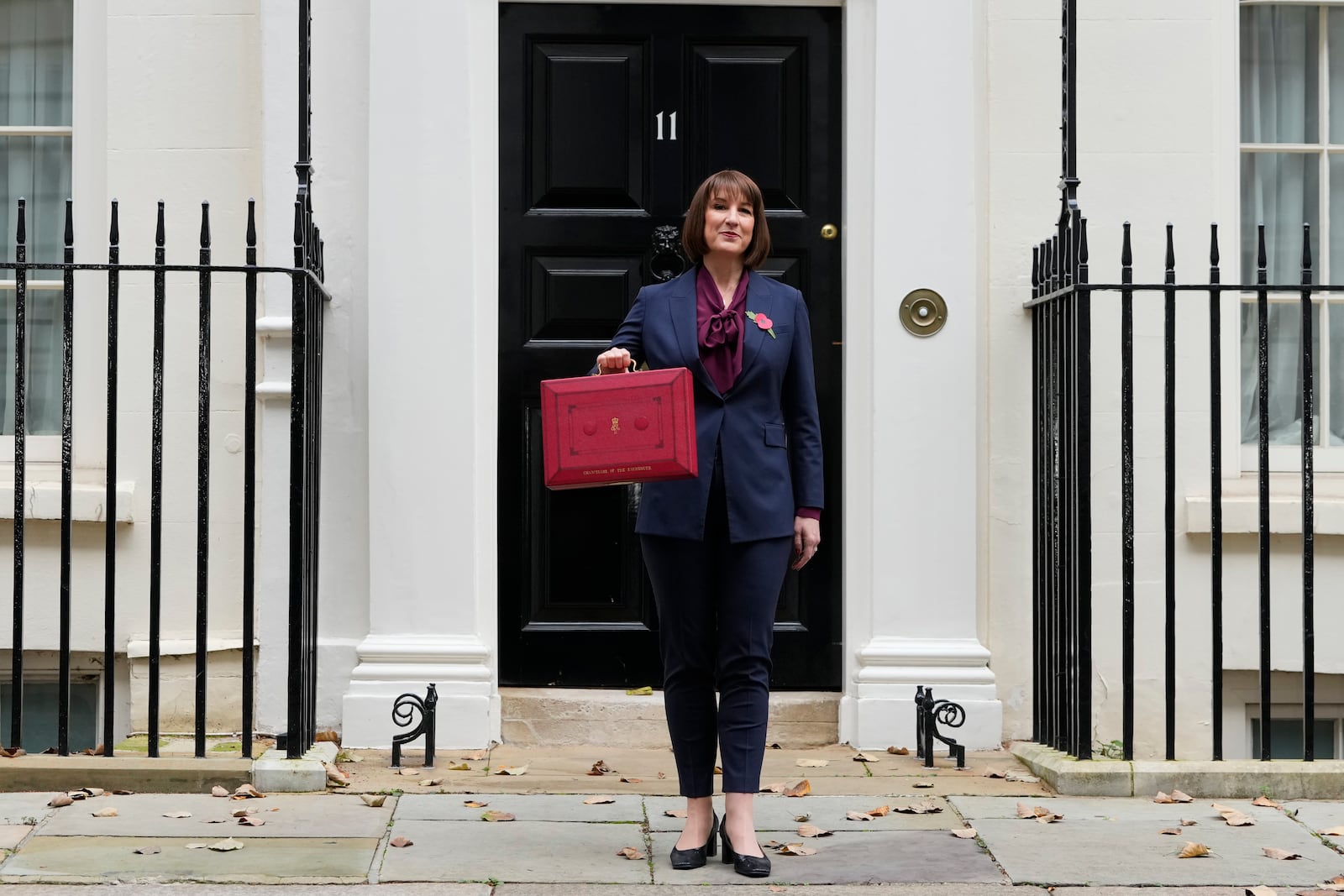 Britain's Chancellor of the Exchequer, Rachel Reeves, holds up the traditional red ministerial box containing her budget speech, as she poses for the media outside No 11 Downing Street, before departing to the House of Commons to deliver the budget in London, Wednesday, Oct. 30, 2024. (AP Photo/Kirsty Wigglesworth)