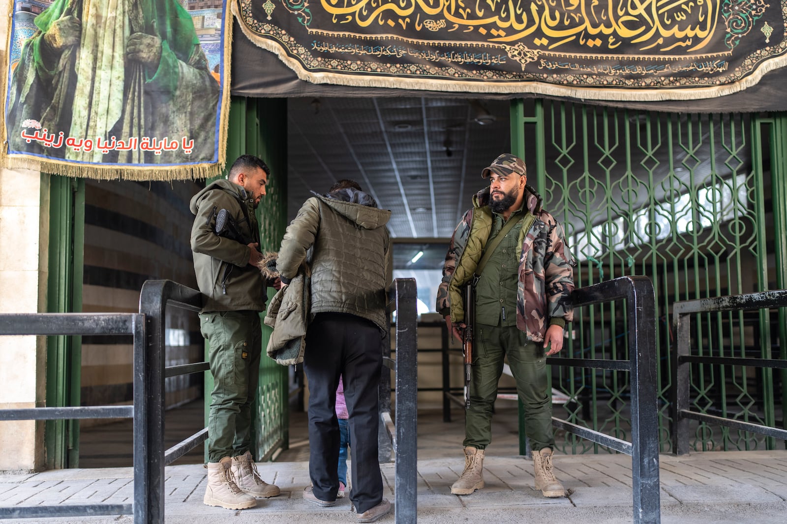 Security members of the new Syrian government inspect people outside the shrine of Sayyida Zaynab, the granddaughter of Prophet Mohammed, in Damascus, Syria, Saturday, Jan. 11, 2025. (AP Photo/Mosa'ab Elshamy)