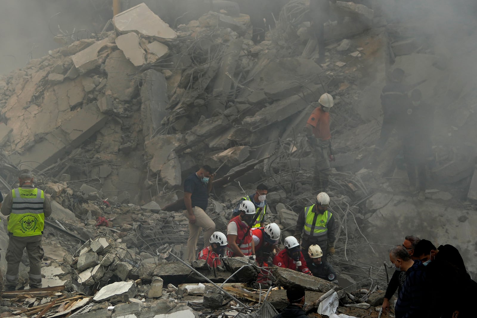 Rescue workers and people search for victims at the site of an Israeli airstrike that hit central Beirut, Lebanon, Saturday, Nov. 23, 2024. (AP Photo/Hassan Ammar)