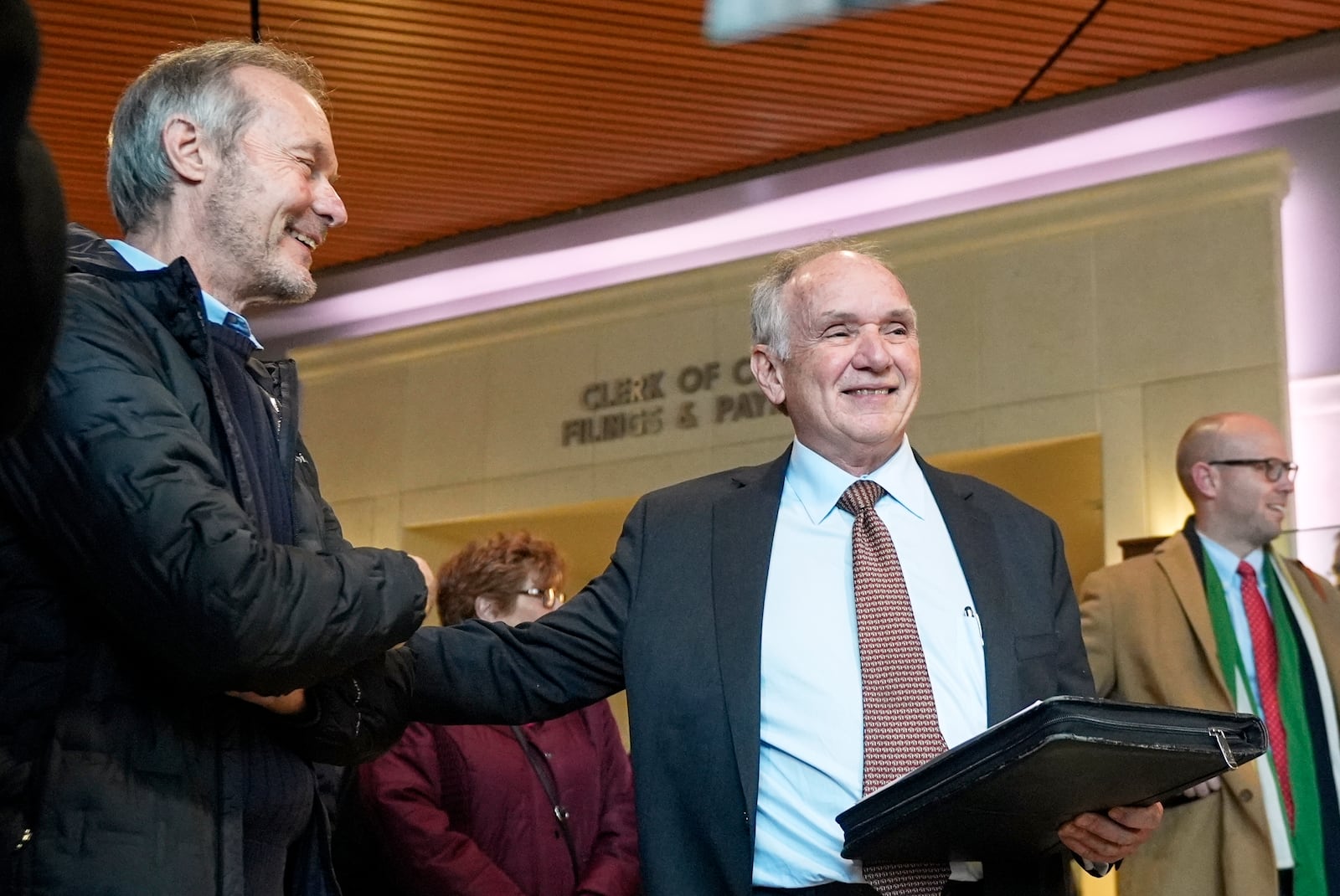 Jim Troupis acknowledges former Wisconsin Gov. Scott McCallum after his court appearance outside a Dane County courtroom Wednesday, Dec. 12, 2024, in Madison, Wis. (AP Photo/Morry Gash)