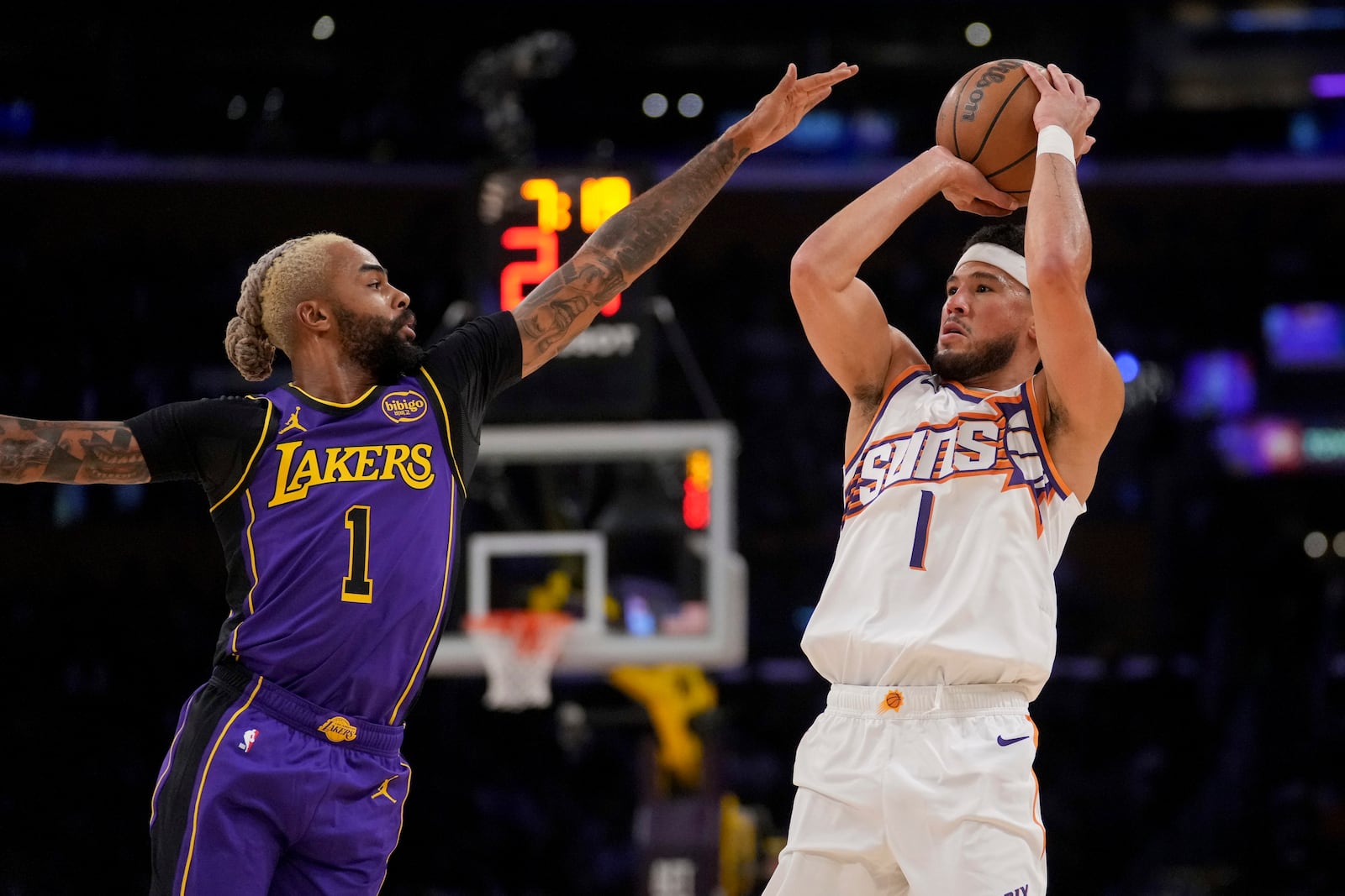 Phoenix Suns guard Devin Booker (1) shoots over Los Angeles Lakers guard D'Angelo Russell (1) during the first half of an NBA basketball game against the in Los Angeles, Friday, Oct. 25, 2024. (AP Photo/Eric Thayer)