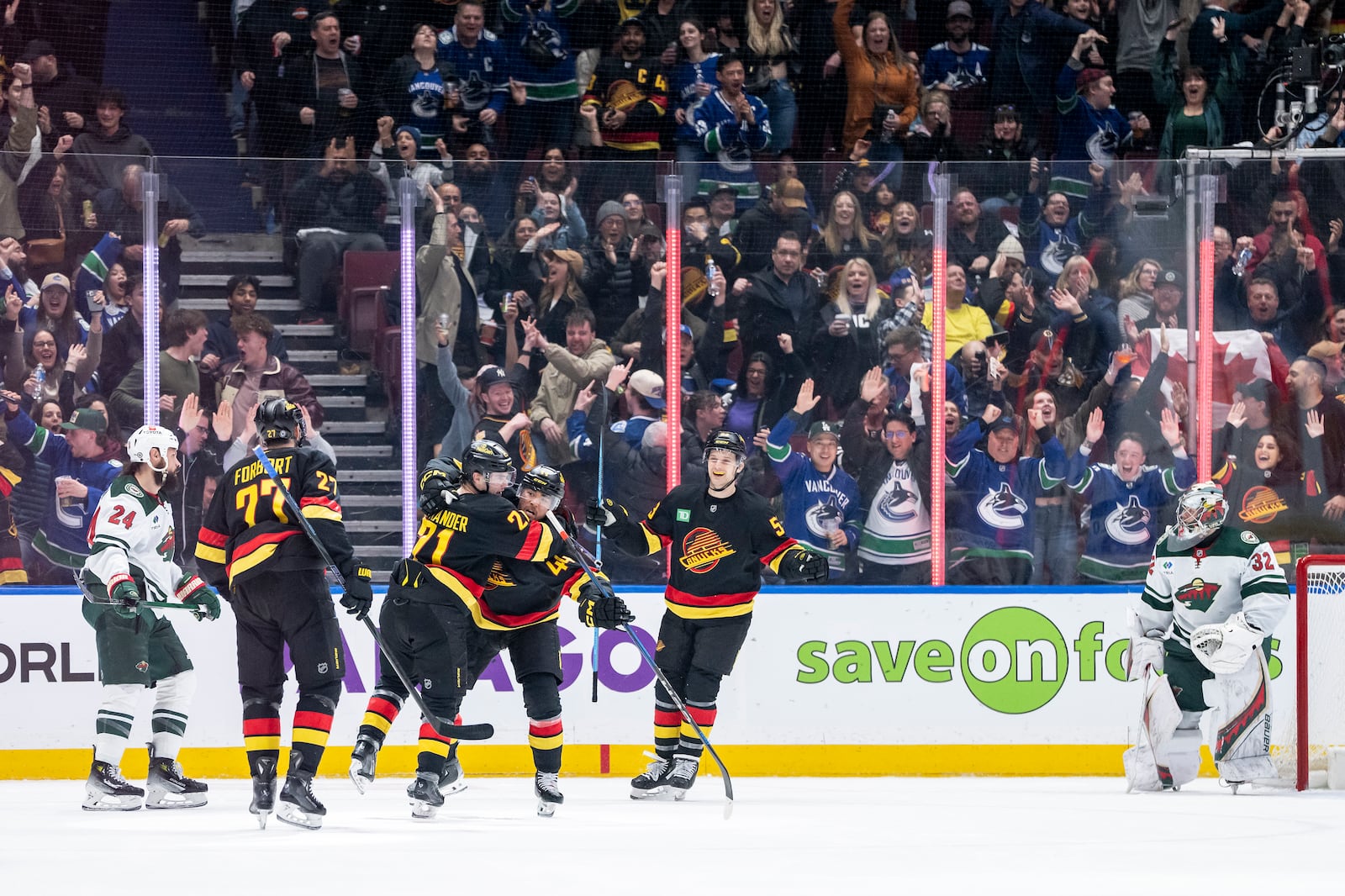 Vancouver Canucks' Kiefer Sherwood (44) celebrates his goal against the Minnesota Wild with Nils Hoglander (21), Derek Forbort (27) and Teddy Blueger (53) while Minnesota Wild's Zach Bogosian (24) and goaltender Filip Gustavsson (32) watch during the third period of an NHL hockey game in Vancouver, British Columbia, Friday, March 7, 2025. (Ethan Cairns/The Canadian Press via AP)