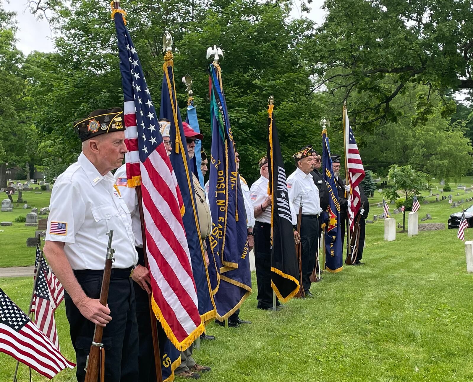 People line up at Oak Dale Cemetery on Saturday during the burial of a young Cable man who died during the Korean War.