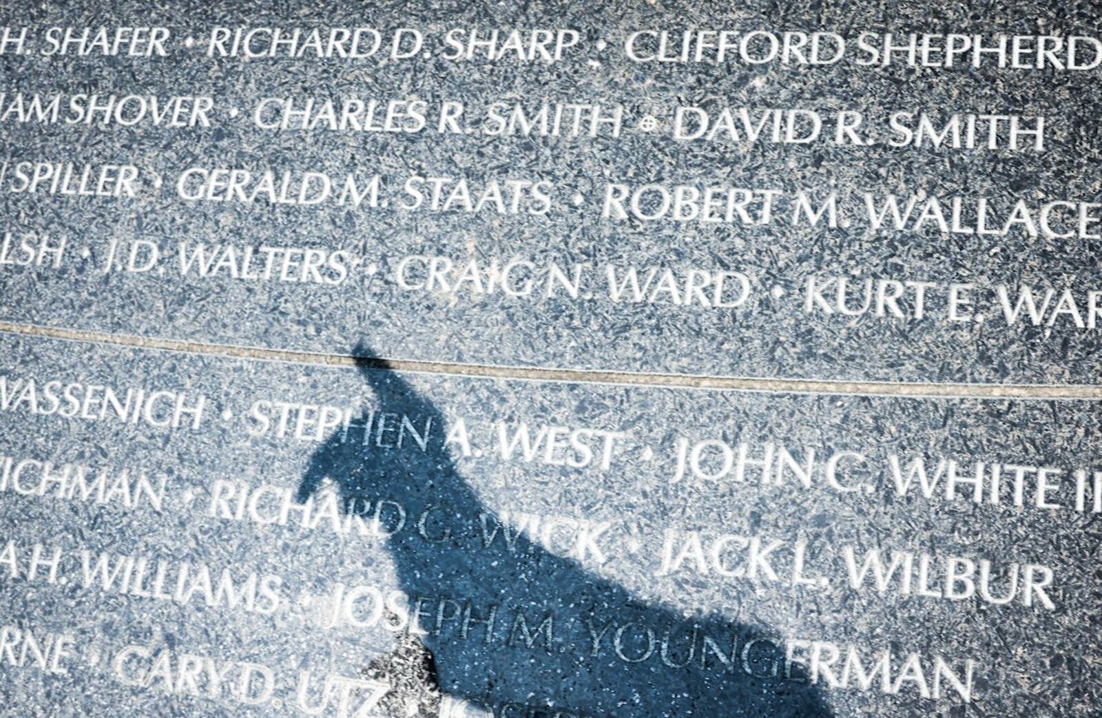 Vietnam veteran Michael Vanderveen points out a lost friend who died during the Vietnam War at the Vietnam Veterans Memorial Park in Dayton Friday May 19, 2023. JIM NOELKER/STAFF