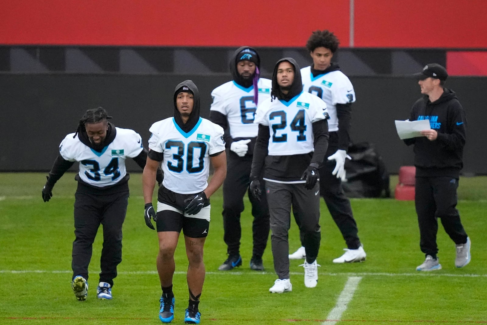 Carolina Panthers running back Chuba Hubbard (30) and Carolina Panthers running back Jonathon Brooks (24) warm up with team mates for a practice session in Munich, Germany, Friday, Nov. 8, 2024. The Carolina Panthers are set to play the New York Giants in an NFL game at the Allianz Arena in Munich on Sunday Nov. 10. (AP Photo/Matthias Schrader)