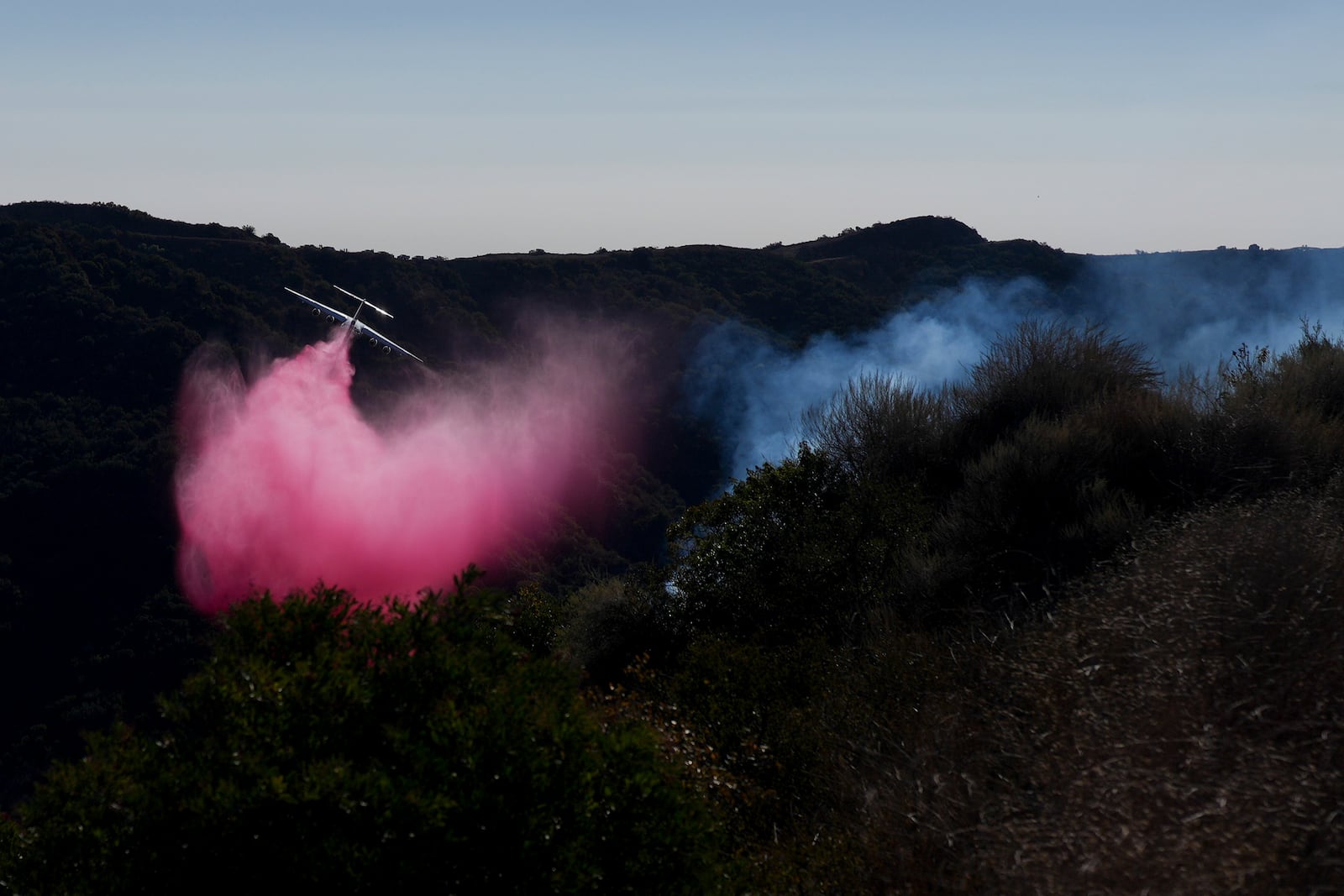 Retardant is dropped by plane on the Palisades Fire in the outskirts of the Pacific Palisades neighborhood of Los Angeles, Friday, Jan. 10, 2025. (AP Photo/Eric Thayer)