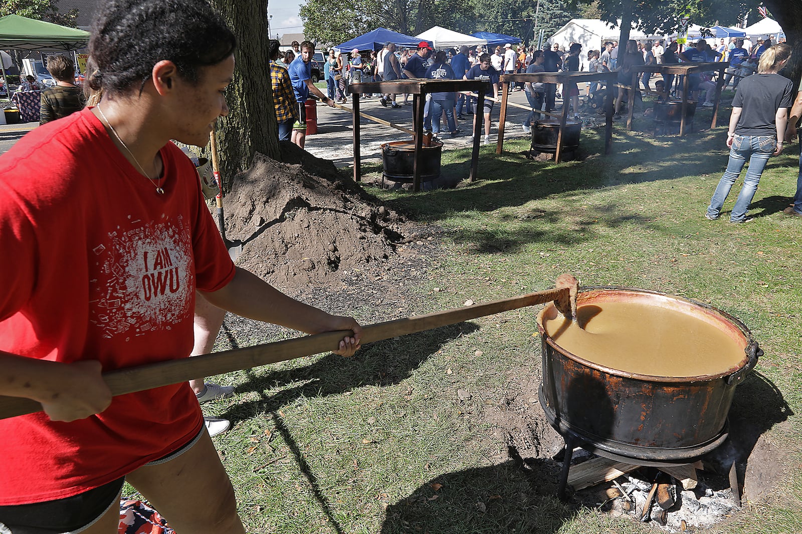 Jennifer Paul takes a turn stirring the apple butter Saturday at the Enon Apple Butter Festival. BILL LACKEY/STAFF