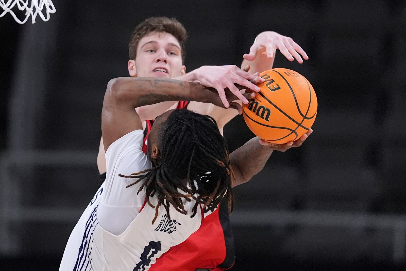 Youngstown State center Gabe Dynes (45) blocks the shot of Robert Morris guard Kam Woods (8) in the second half of an NCAA college basketball game in the championship of the Horizon League tournament in Indianapolis, Tuesday, March 11, 2025. (AP Photo/Michael Conroy)