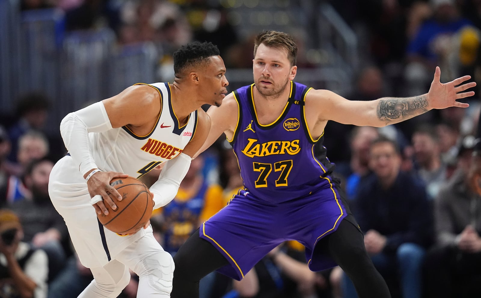 Denver Nuggets guard Russell Westbrook, left, looks to pass the ball as Los Angeles Lakers guard Luka Doncic defends in the first half of an NBA basketball game Saturday, Feb. 22, 2025, in Denver. (AP Photo/David Zalubowski)