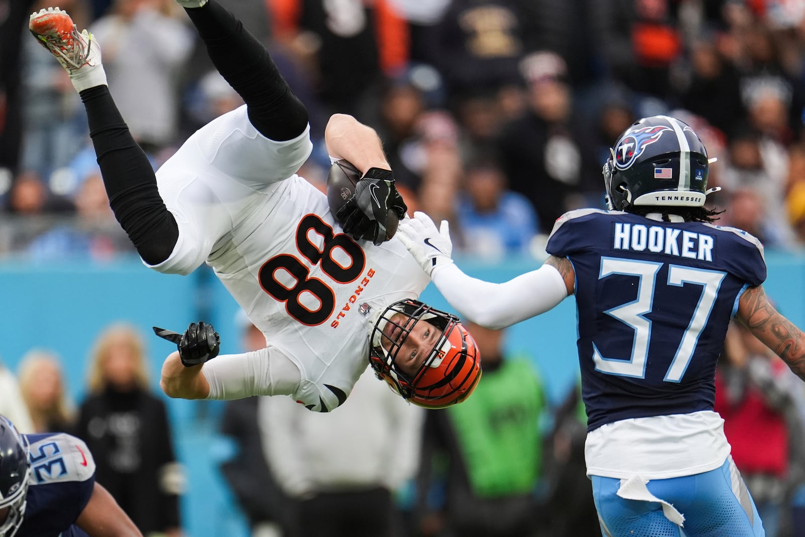 Cincinnati Bengals tight end Mike Gesicki (88) is flipped into the air by Tennessee Titans cornerback Daryl Worley (35) as safety Amani Hooker (37) looks on during the first half of an NFL football game Sunday, Dec. 15, 2024, in Nashville, Tenn. (AP Photo/George Walker IV)