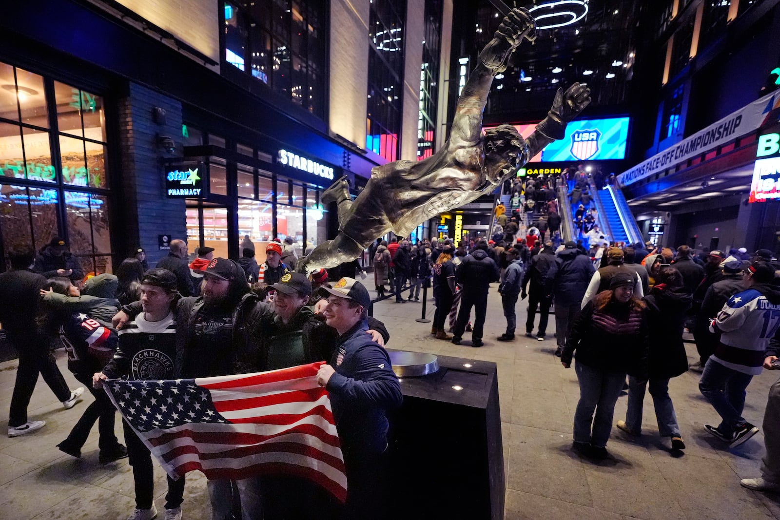 Fans unfurl an American flag next to the statue of NHL Hall of Famer Bobby Orr prior to the 4 Nations Face-Off Championship hockey game, Thursday, Feb. 20, 2025, in Boston. (AP Photo/Charles Krupa)