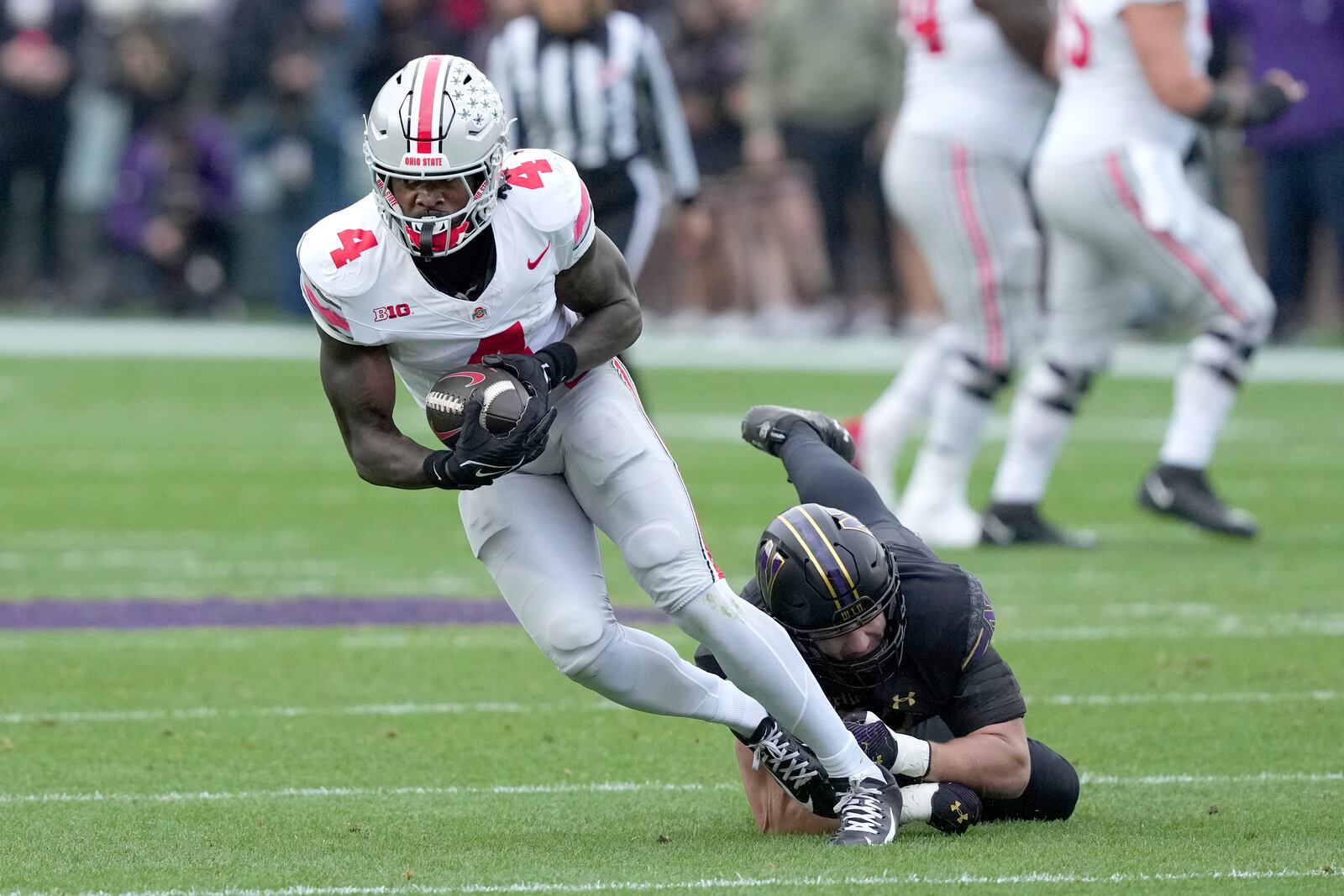 Ohio State wide receiver Jeremiah Smith catches a pass as Northwestern linebacker Greyson Metz defends during the first half of an NCAA college football game at Wrigley Field on Saturday, Nov. 16, 2024, in Chicago. (AP Photo/Charles Rex Arbogast)