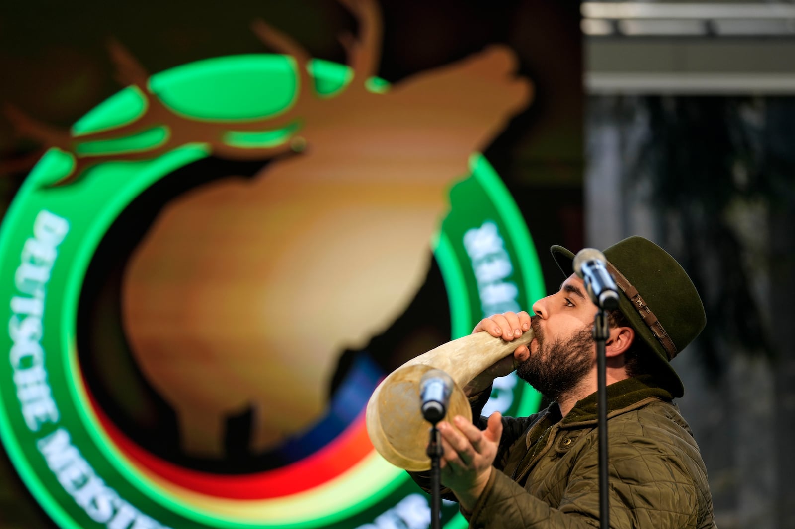 Jerome Boehm performs to imitate a stag in heat during the German Championship of Deer-Calling at the hunting fair in Dortmund, Germany, Friday, Jan. 31, 2025. (AP Photo/Martin Meissner)