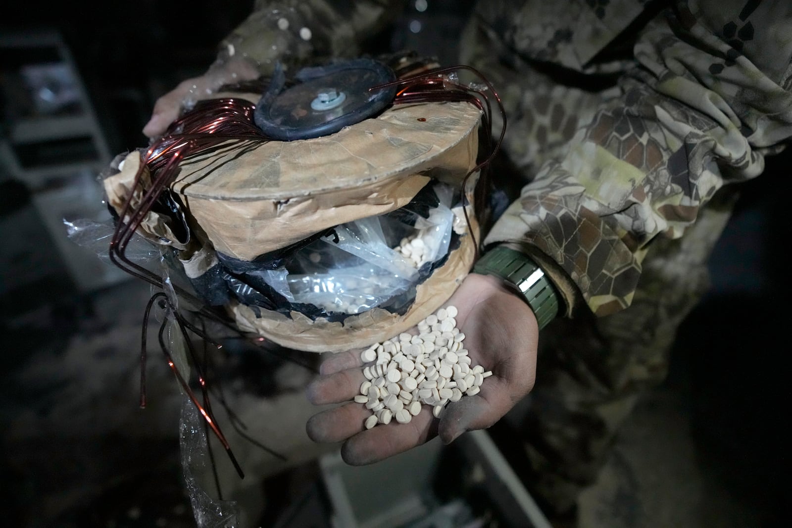 A Syrian member of the rebel shows amphetamine pills known as Captagon hidden inside an electrical component at the warehouse where the drug was manufactured before the fall of Bashar Assad government at a facility in Douma city, outskirts of Damascus, Syria, Friday, Dec. 13, 2024. (AP Photo/Hussein Malla)