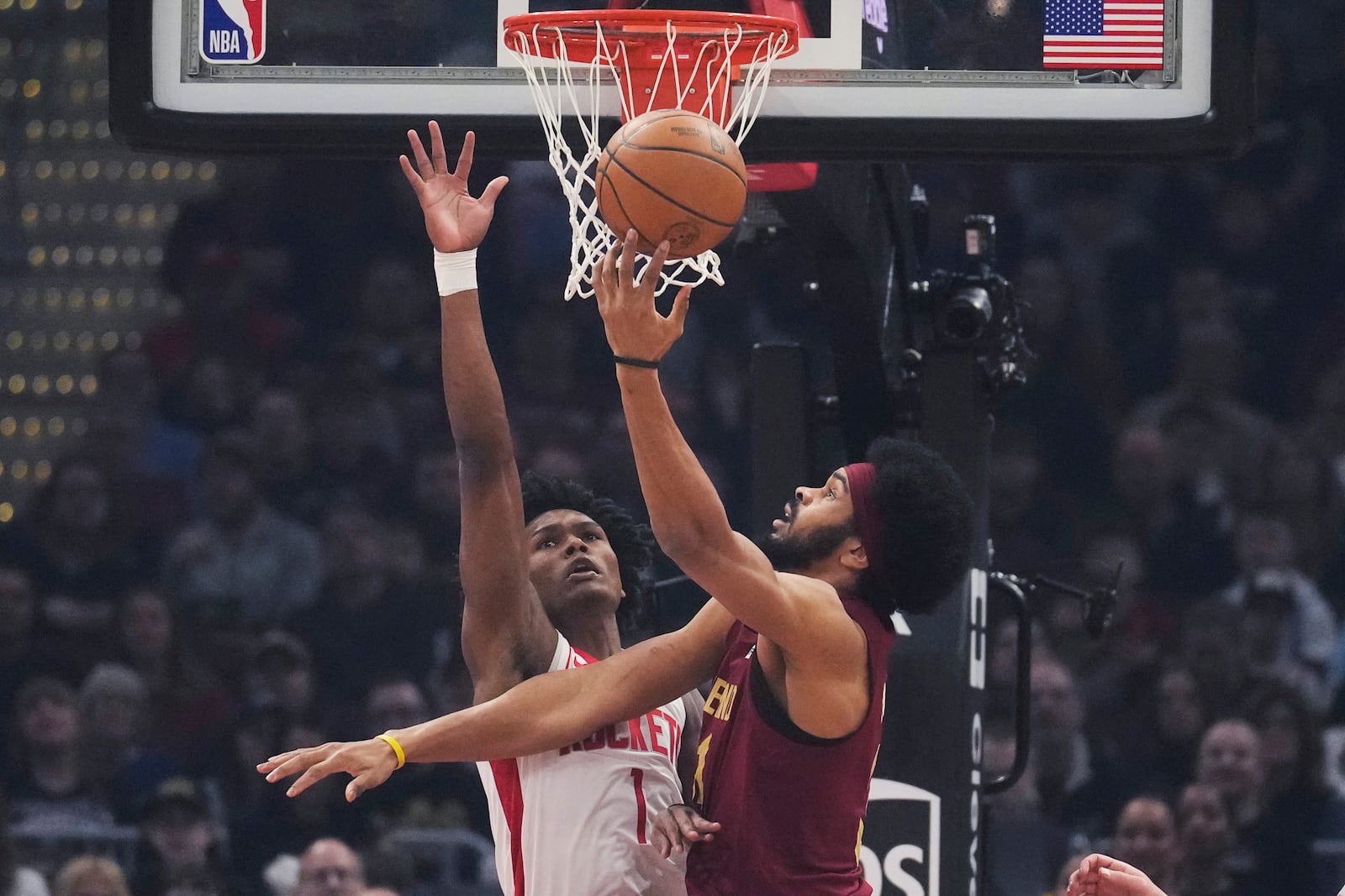 Cleveland Cavaliers center Jarrett Allen, right, shoots as Houston Rockets forward Amen Thompson (1) defends in the first half of an NBA basketball game, Saturday, Jan. 25, 2025, in Cleveland. (AP Photo/Sue Ogrocki)