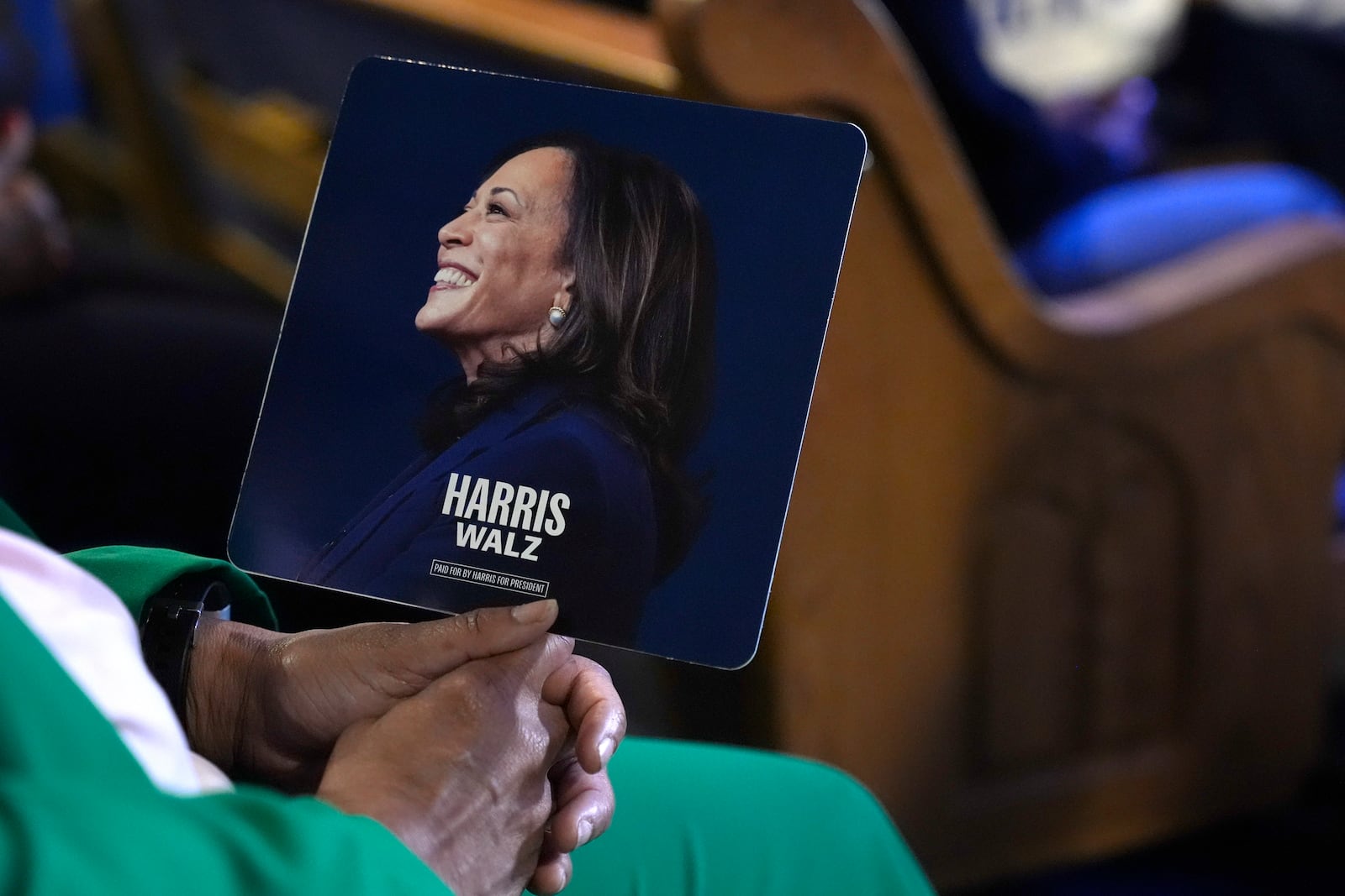 An attendee holds a campaign fan before Democratic presidential nominee Vice President Kamala Harris arrives to speak during a church service and early vote event at Divine Faith Ministries International, Sunday, Oct. 20, 2024, in Jonesboro, Ga. (AP Photo/Jacquelyn Martin)