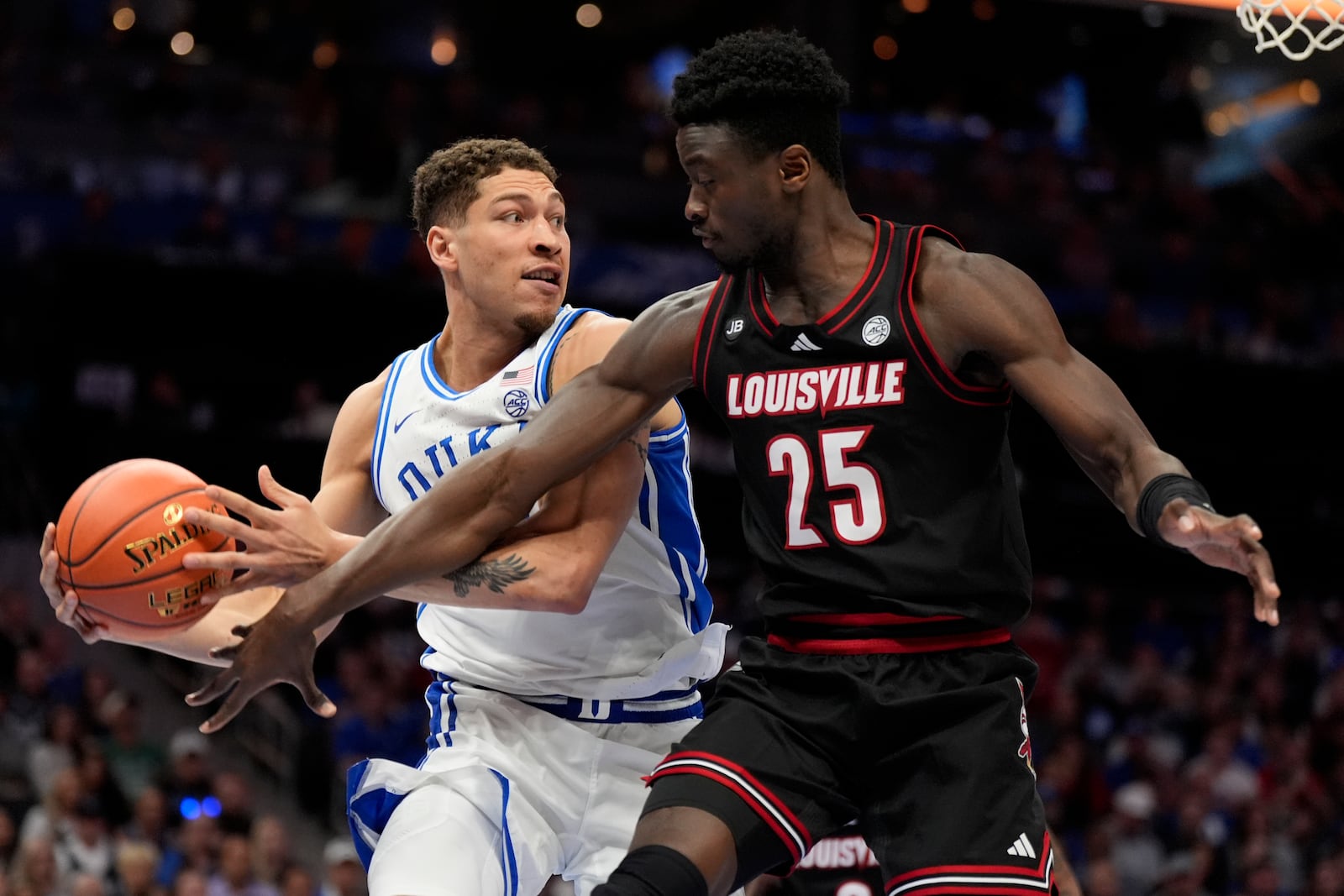 Duke forward Mason Gillis, left, vies for the ball with Louisville forward Aboubacar Traore during the first half of an NCAA college basketball game in the championship of the Atlantic Coast Conference tournament, Saturday, March 15, 2025, in Charlotte, N.C. (AP Photo/Chris Carlson)