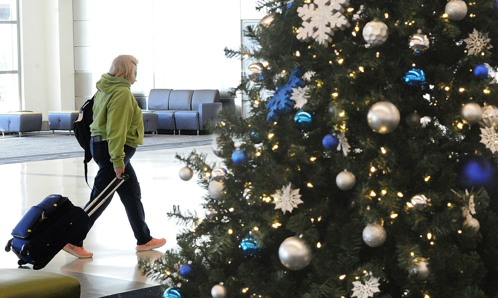 A lone traveler makes her way through the Dayton International Airport on Monday, Dec. 20, 2021. MARSHALL GORBY\STAFF