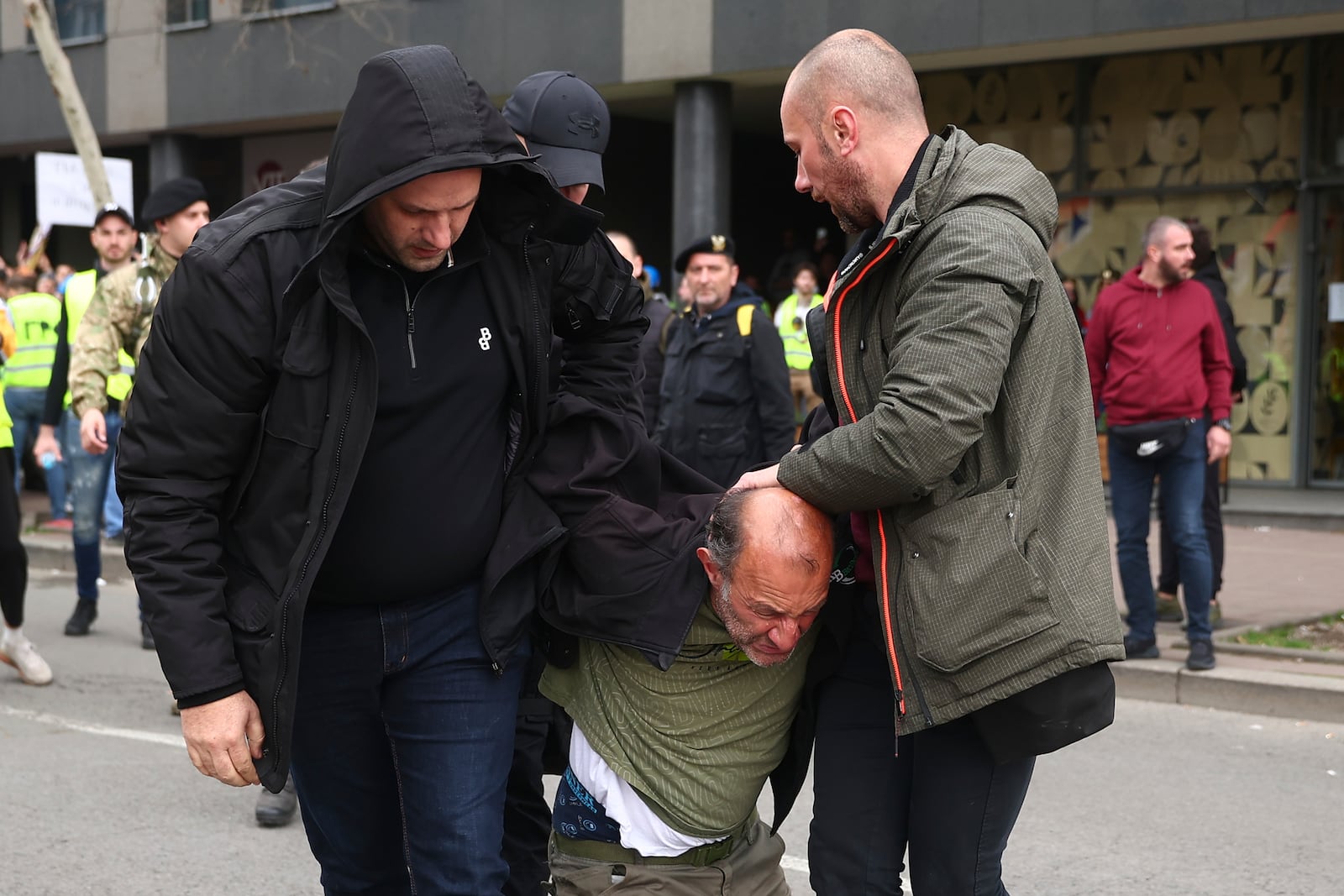 A man who allegedly claimed he was armed with bombs is detained by plain clothed police during a major rally against populist President Aleksandar Vucic and his government, in downtown Belgrade, Serbia, Saturday, March 15, 2025. (AP Photo/Armin Durgut)