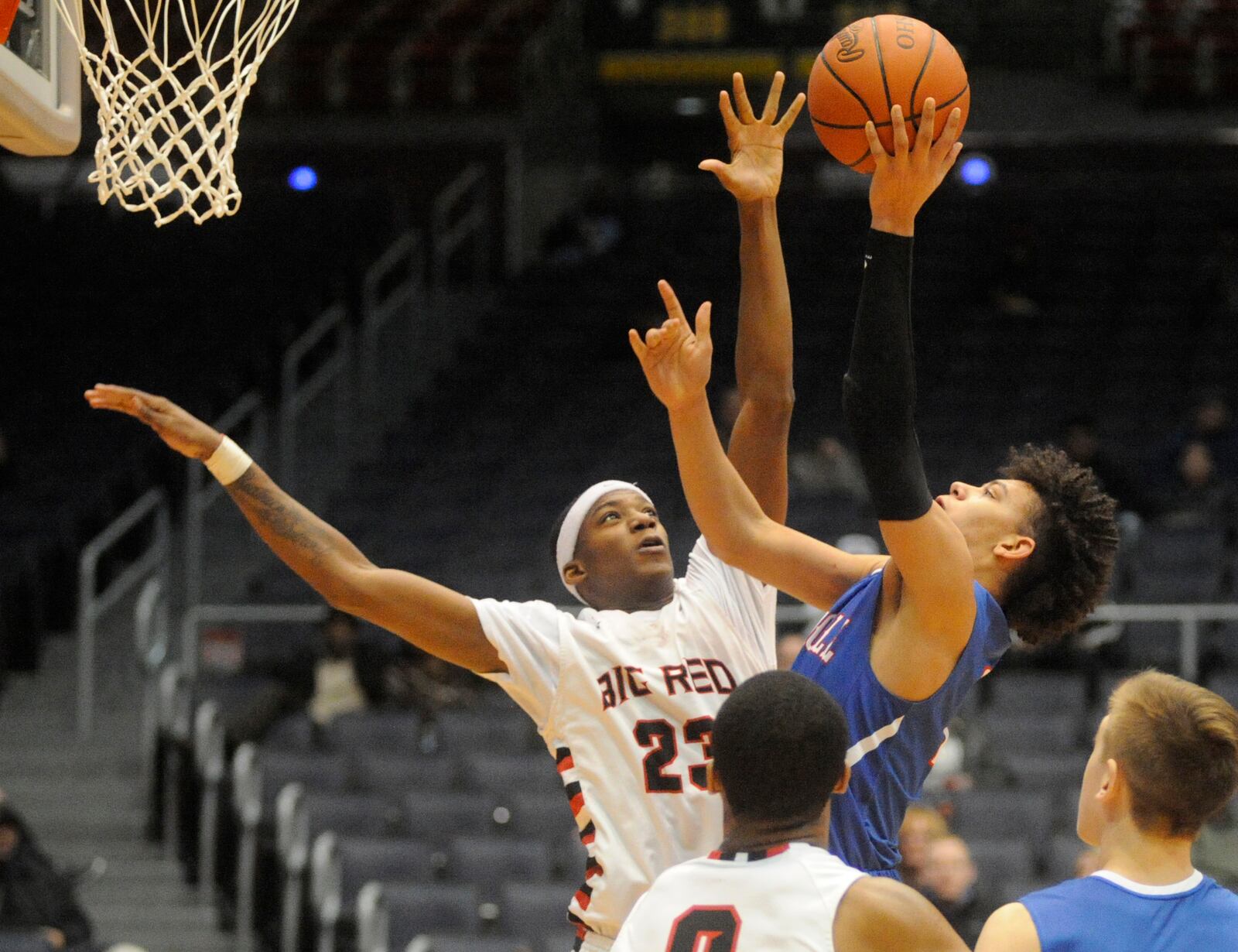 D.J. Brewton of Hughes (left) battles Eli Ramsey of Carroll for a rebound. MARC PENDLETON / STAFF