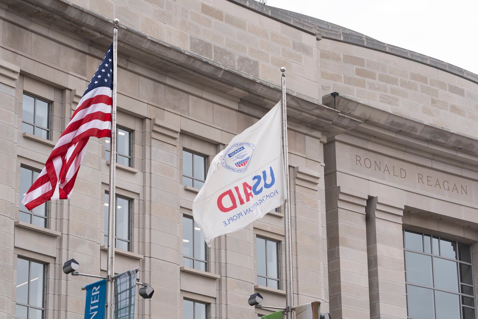 The flag of the United States Agency for International Development, or USAID, right, flies alongside the American flag in front the USAID office in Washington, Monday, Feb. 3, 2025. (AP Photo/Manuel Balce Ceneta)