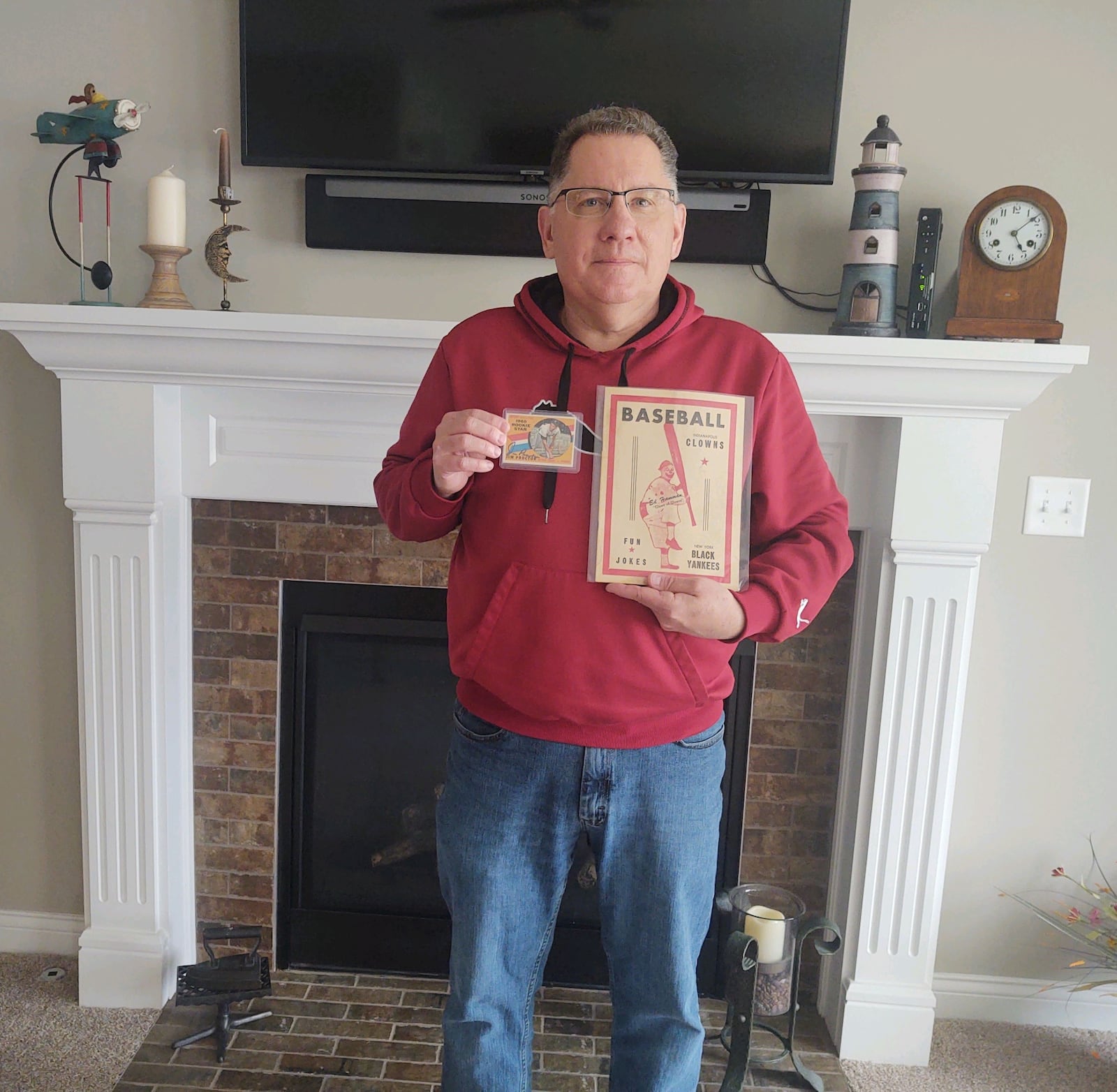 Todd Osborne, a retired U.S. Air Force master sergeant and current program manager at Wright Patterson AFB from Beavercreek Township, holds the Topps rookie card of Detroit Tigers pitcher Jim Proctor and also a memento from his Negro Leagues collection,  a 1955 game program between the Indianapolis Clowns and the New York Black Yankees. Proctor, a Black Yankees pitcher (back row, second from left) is the grandfather of Dayton Dragons pitcher James Proctor. Todd Osborne/CONTRIBUTED