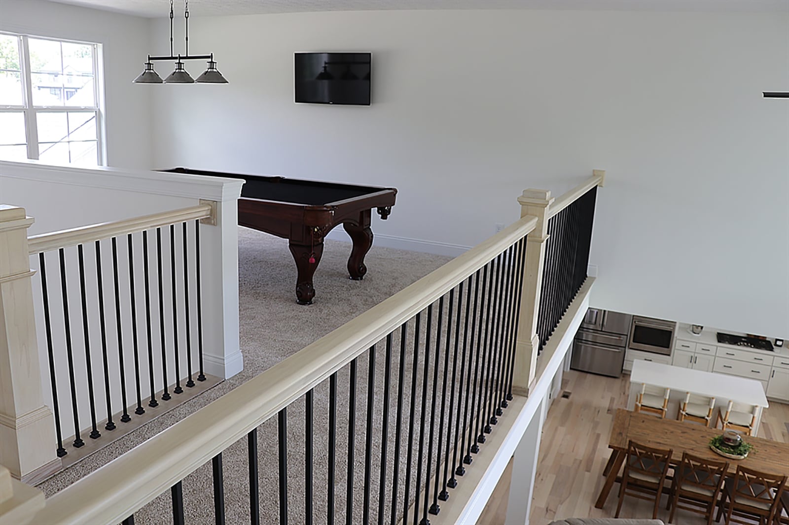 The white-pine banister and railing with dark, wrought-iron spindles ascend the stairwell and wrap around the upstairs hallway and loft family room. CONTRIBUTED PHOTO BY KATHY TYLER